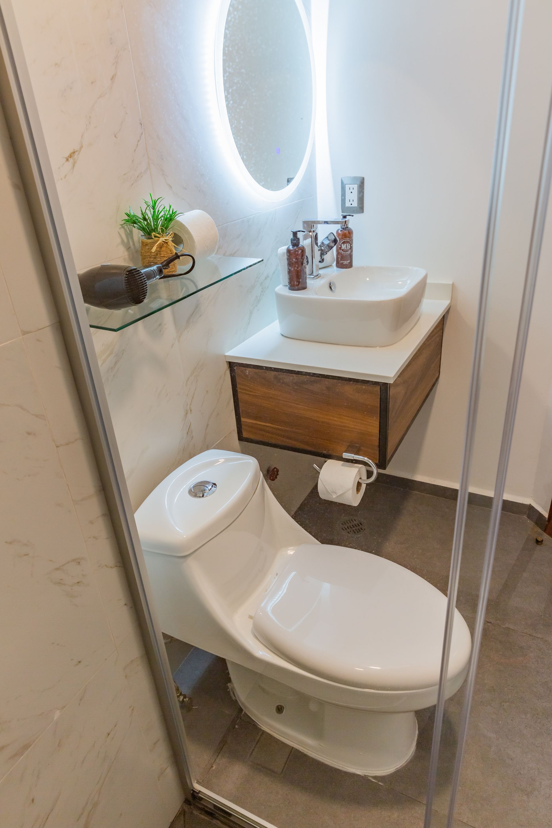Un baño con inodoro, lavabo y espejo.
