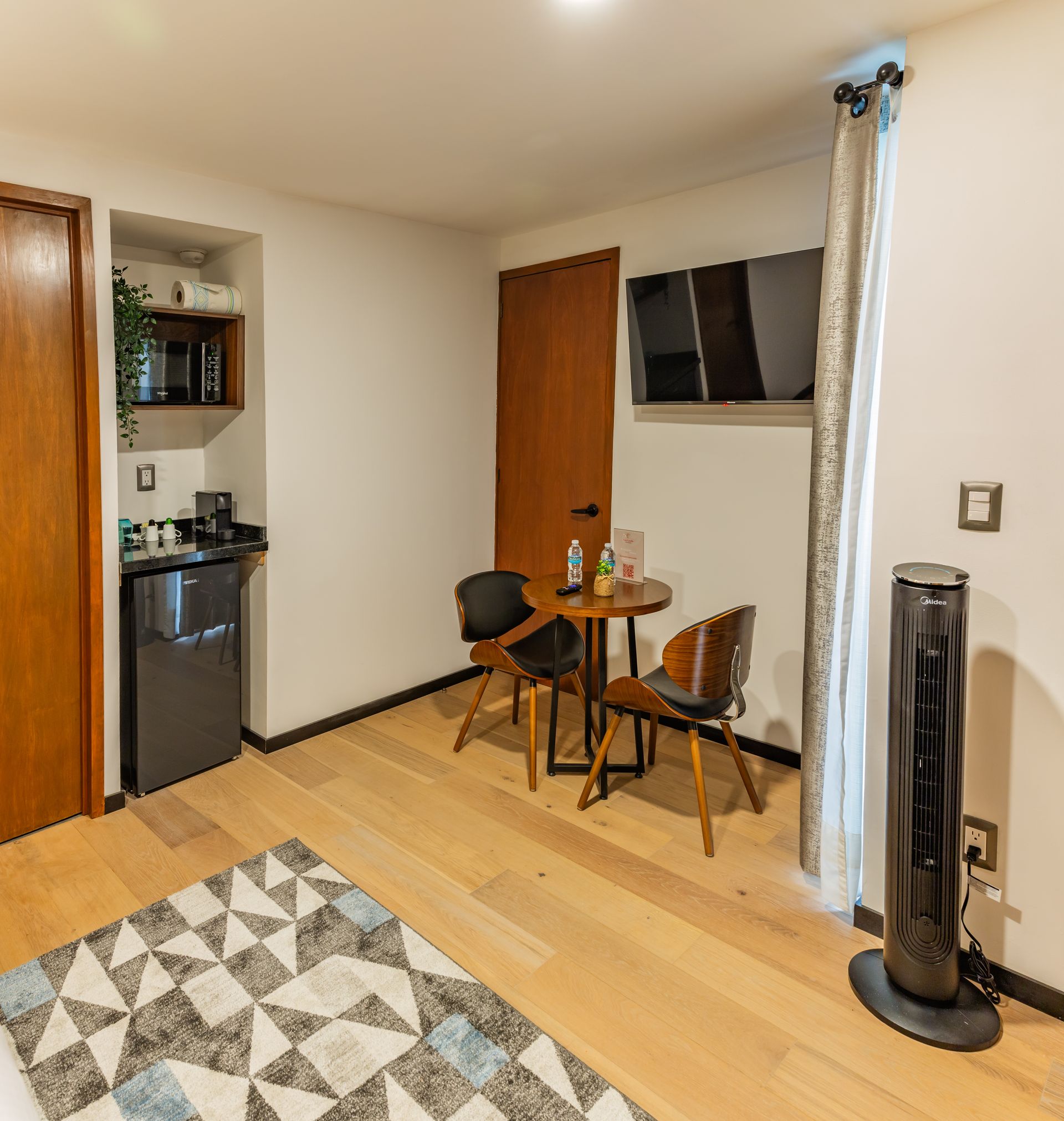 Una habitación con una mesa y sillas y un ventilador.