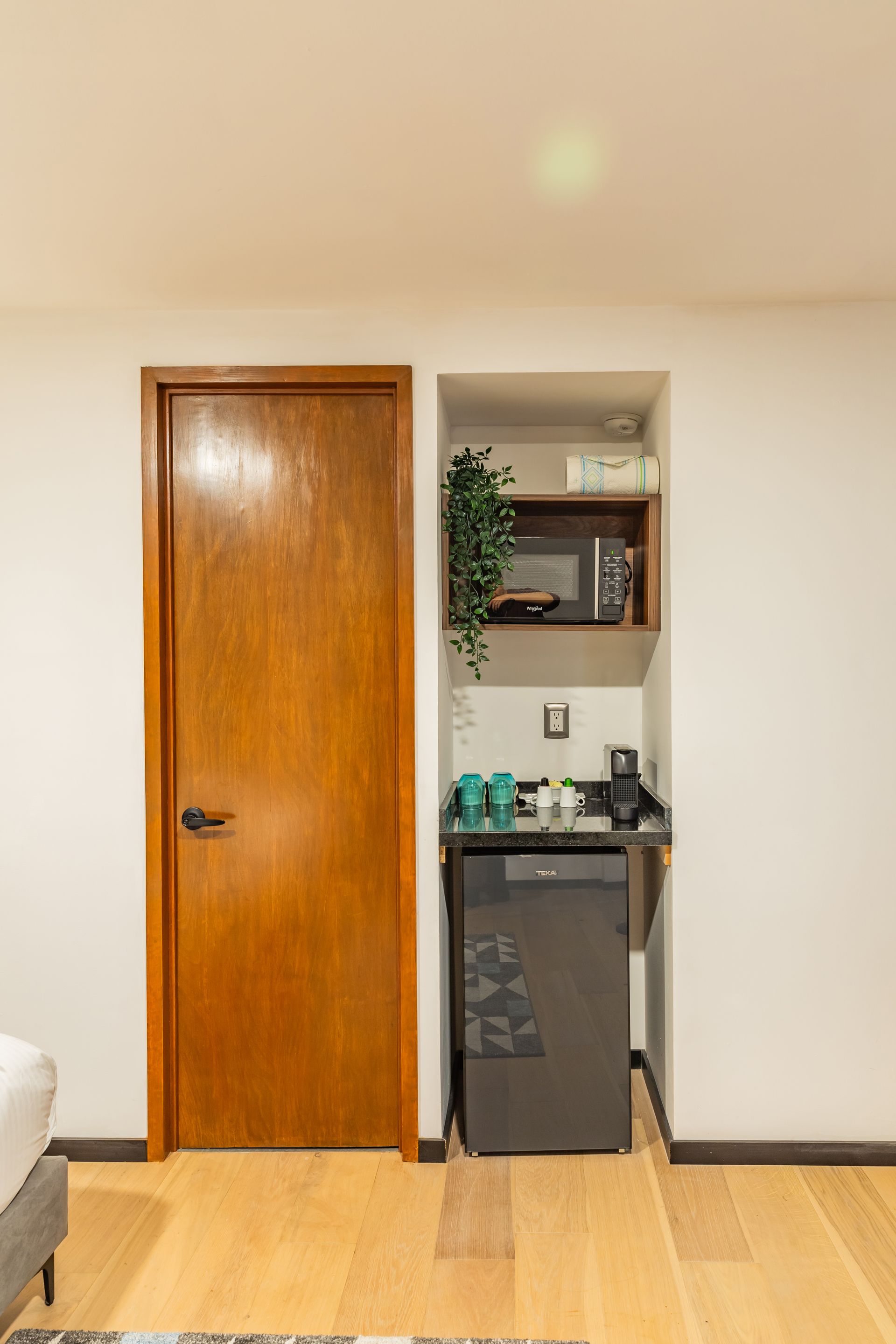 Una pequeña cocina con refrigerador, microondas y fregadero.