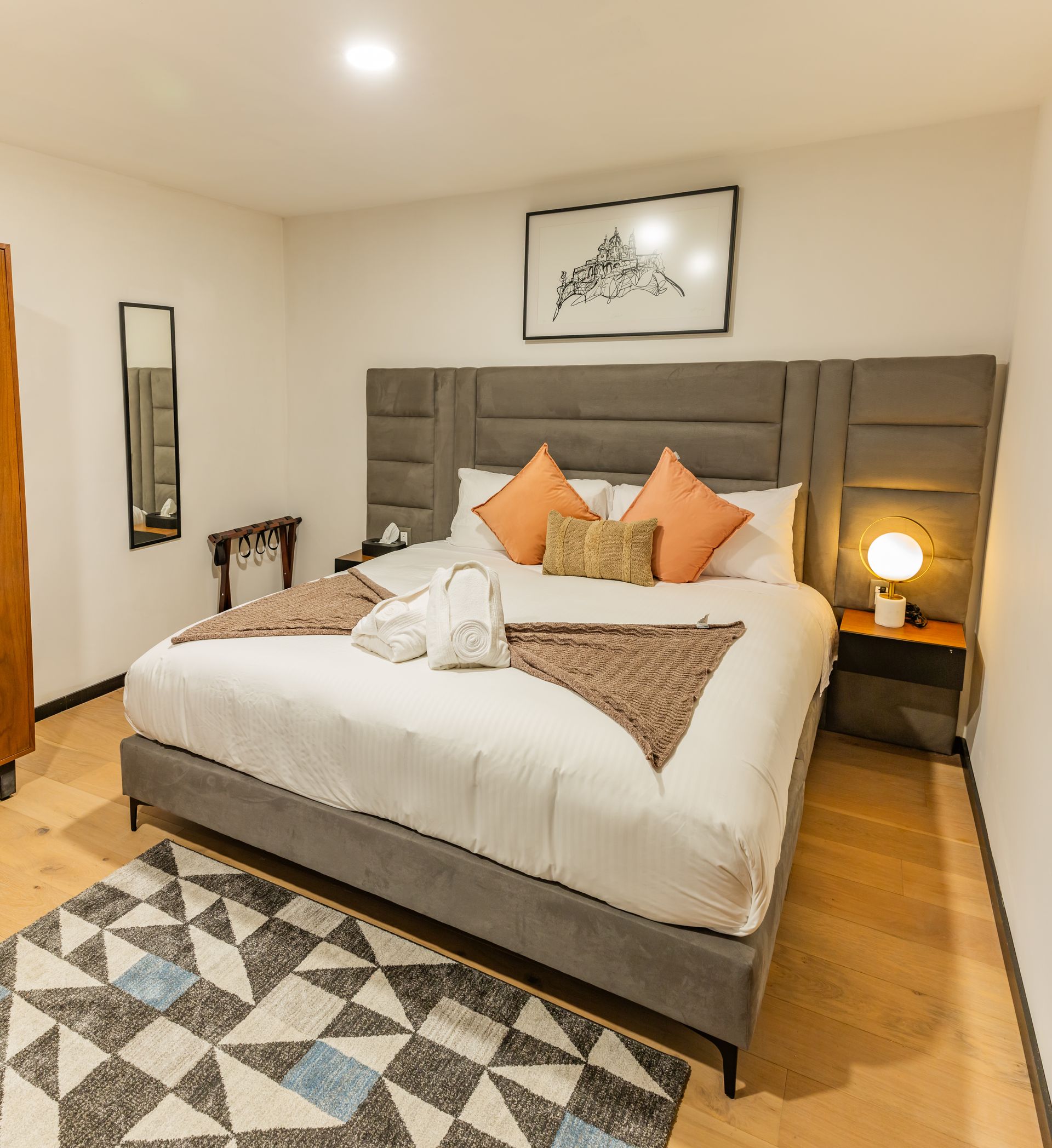 Un dormitorio con una cama king size y una alfombra.