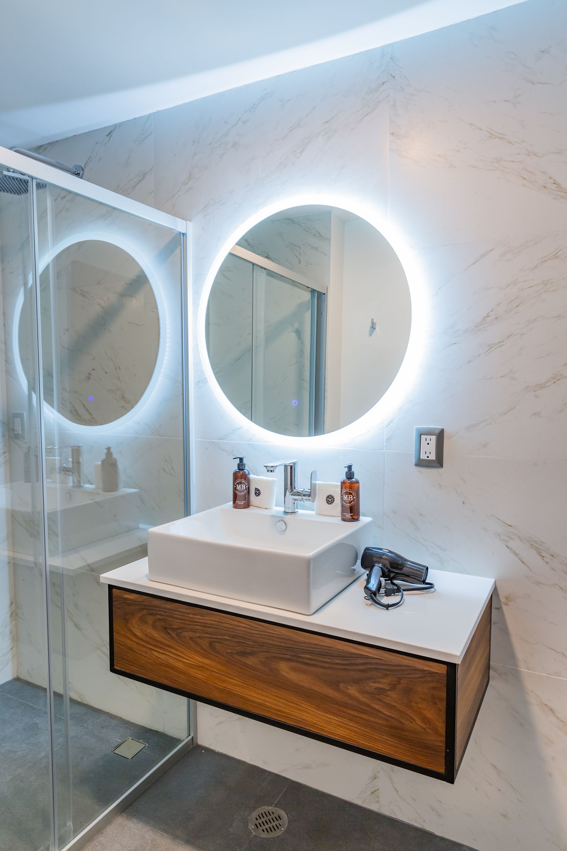 Un baño con lavabo, espejo y ducha.