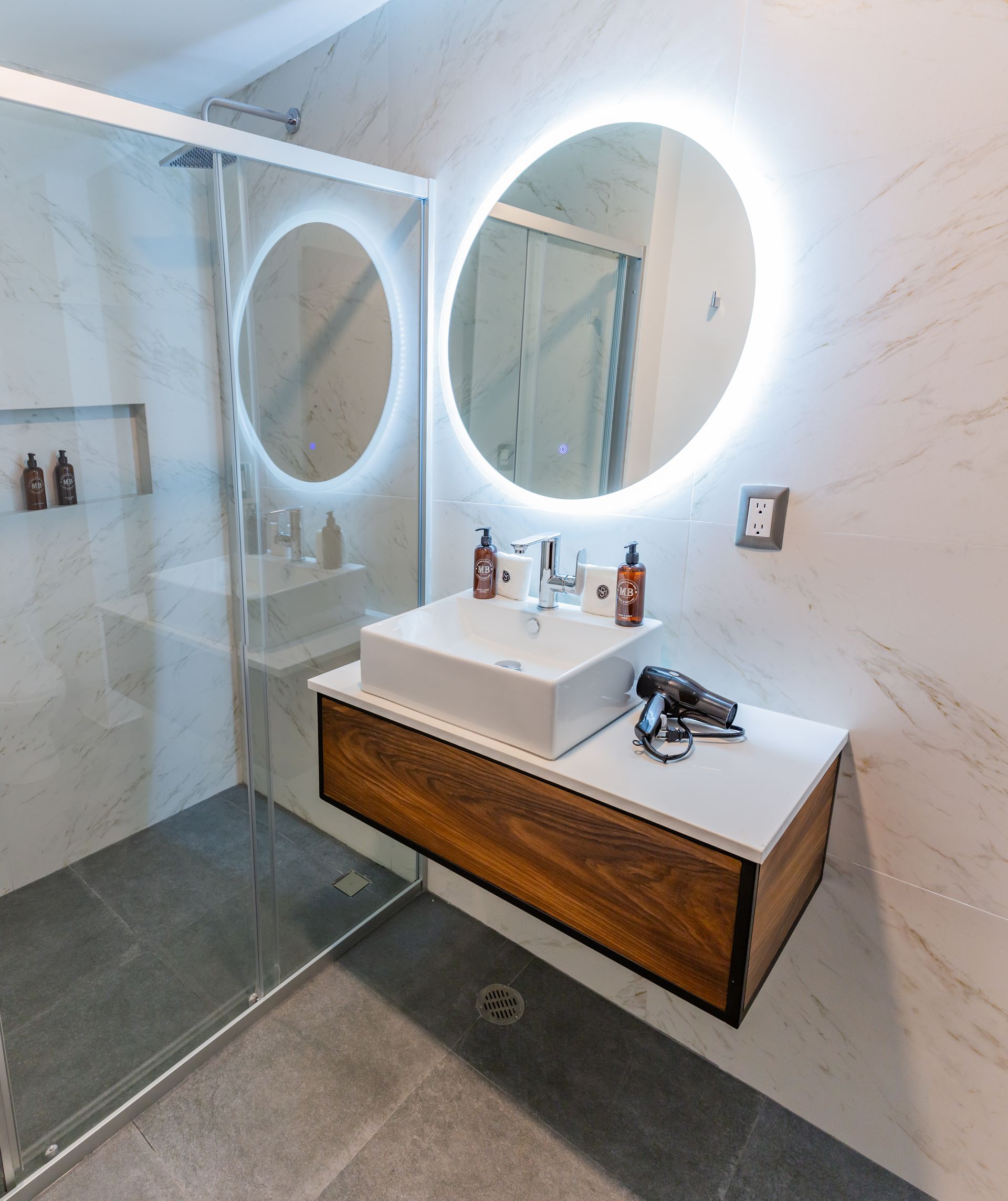 Un baño con lavabo, espejo y ducha.