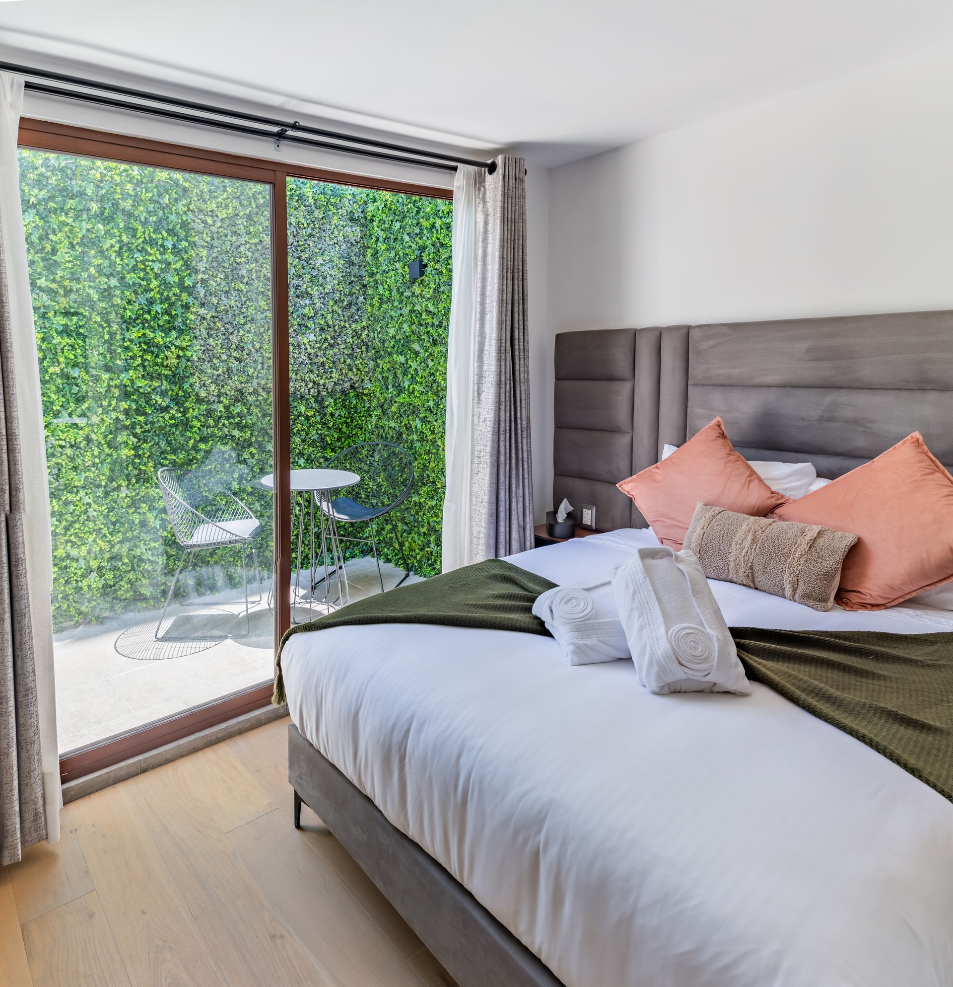 Un dormitorio con una cama grande y una puerta corrediza de cristal.