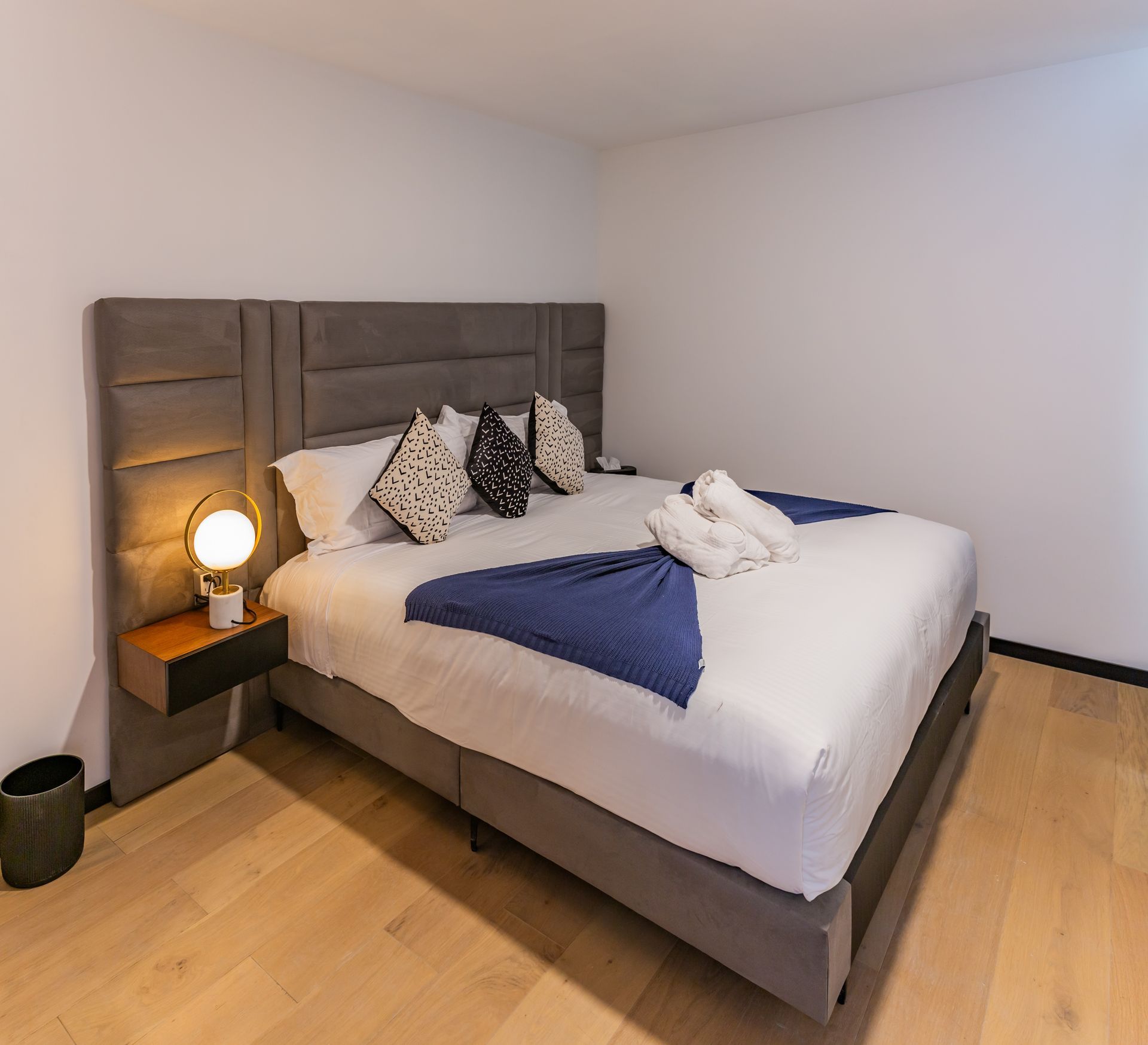 Un dormitorio con una cama king size y una lámpara en la mesita de noche.