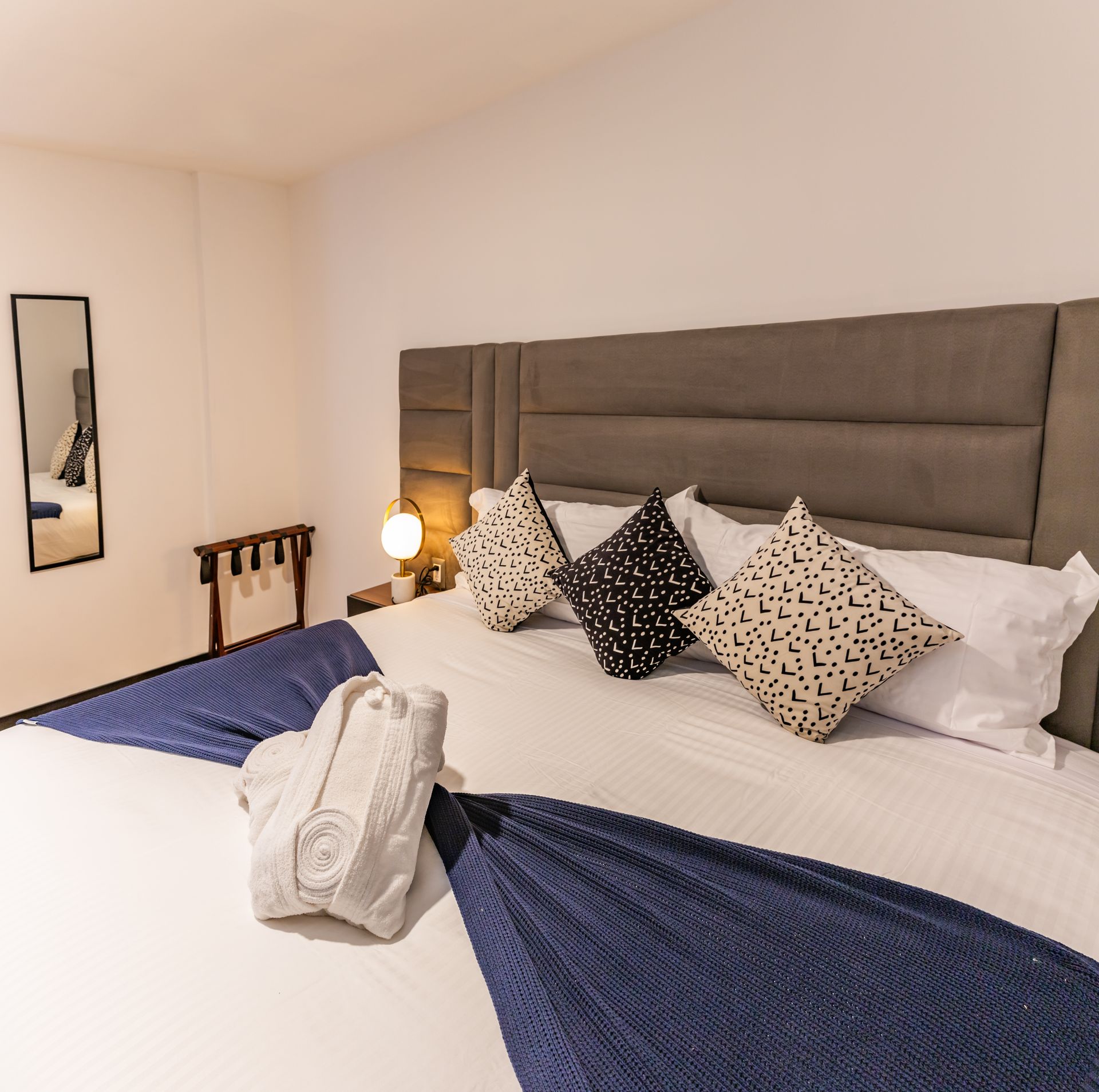 Una habitación de hotel con una cama grande y almohadas.