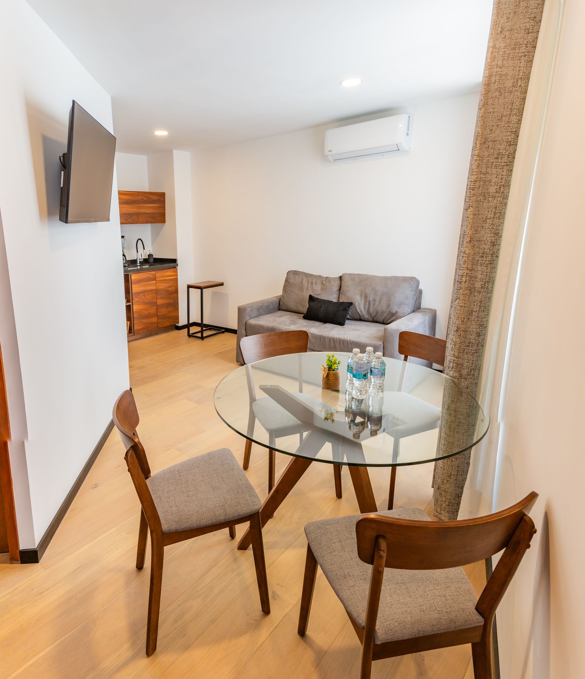 Una sala de estar con una mesa de cristal y sillas.