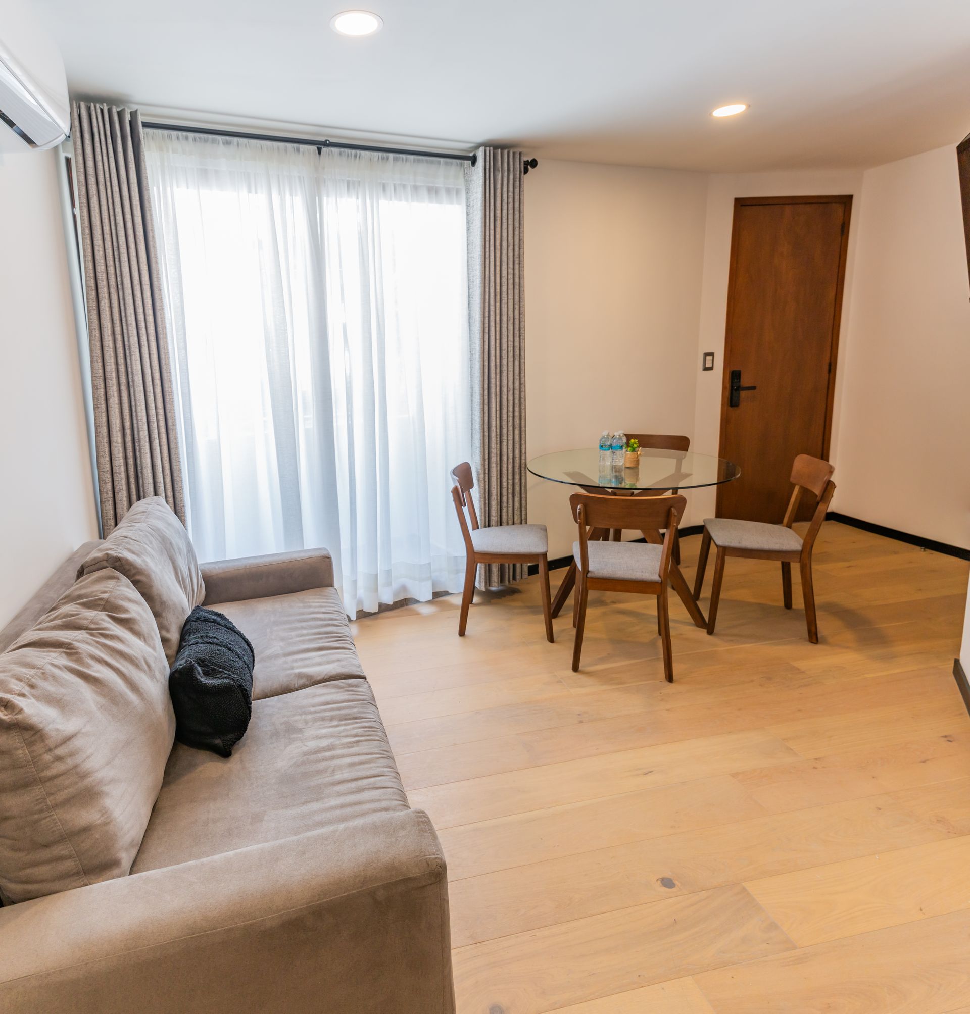 Una sala de estar con sofá, mesa y sillas.