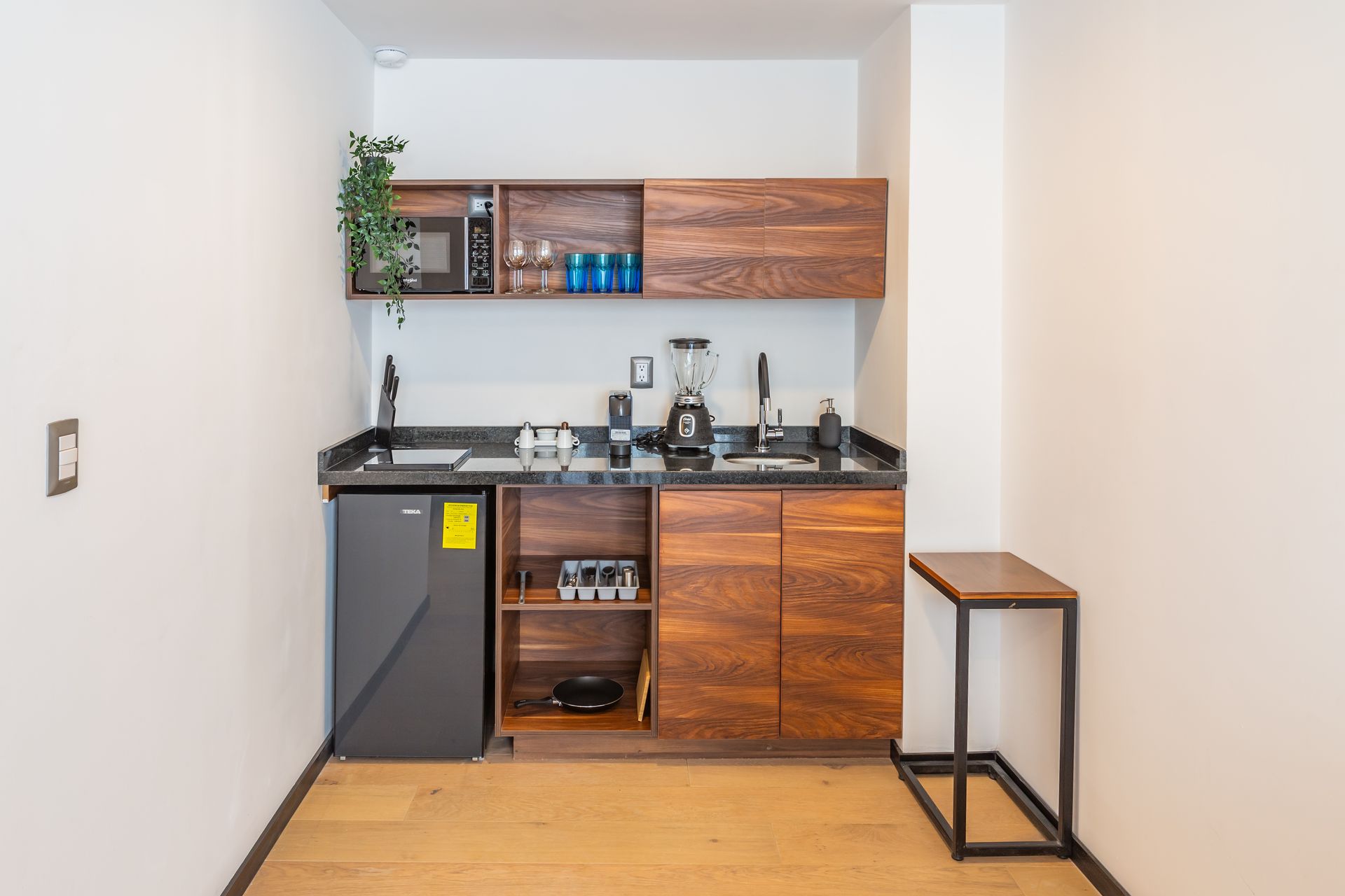 Una pequeña cocina con gabinetes de madera y refrigerador.
