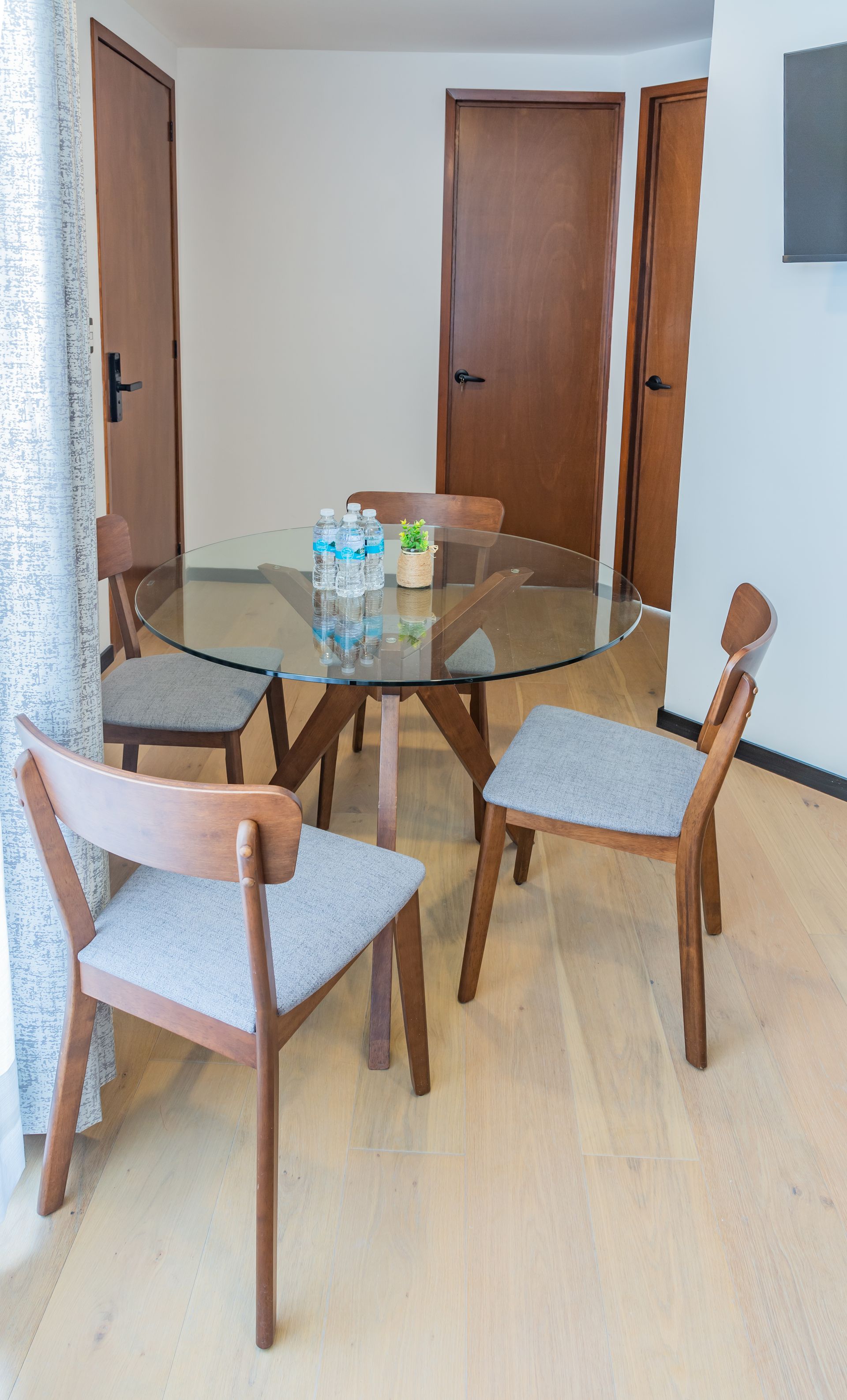 Hay una mesa de cristal y sillas en la habitación.