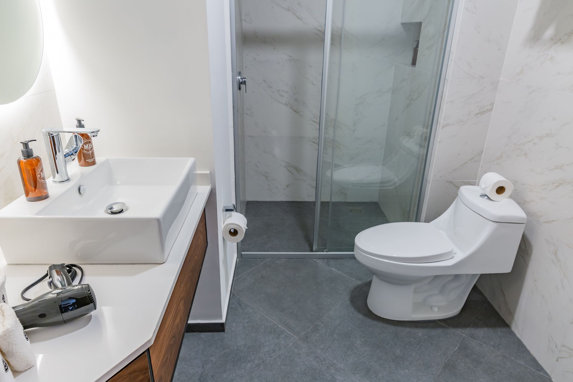 Un baño con inodoro, lavabo y ducha.