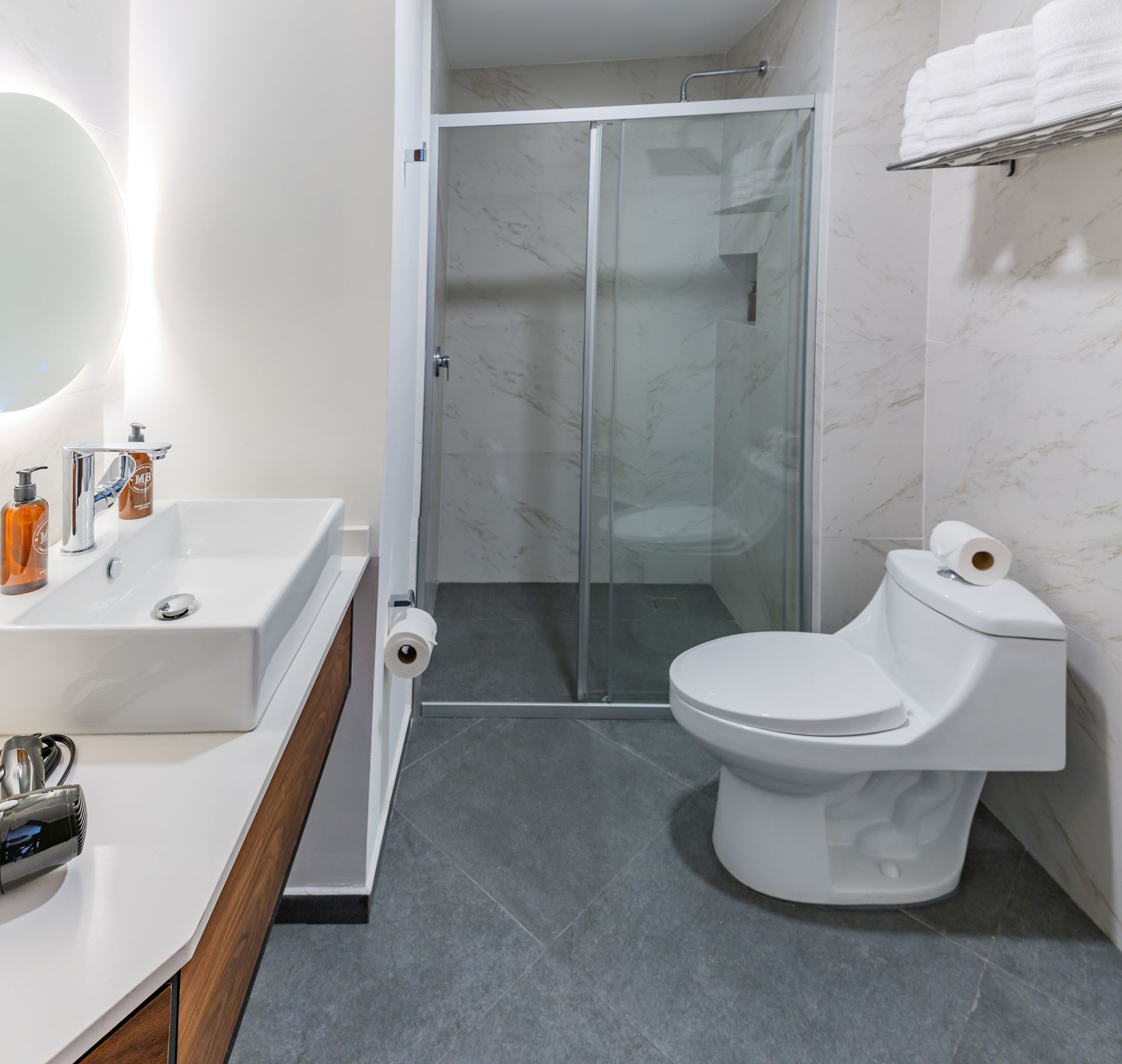 Un baño con inodoro, lavabo y espejo.