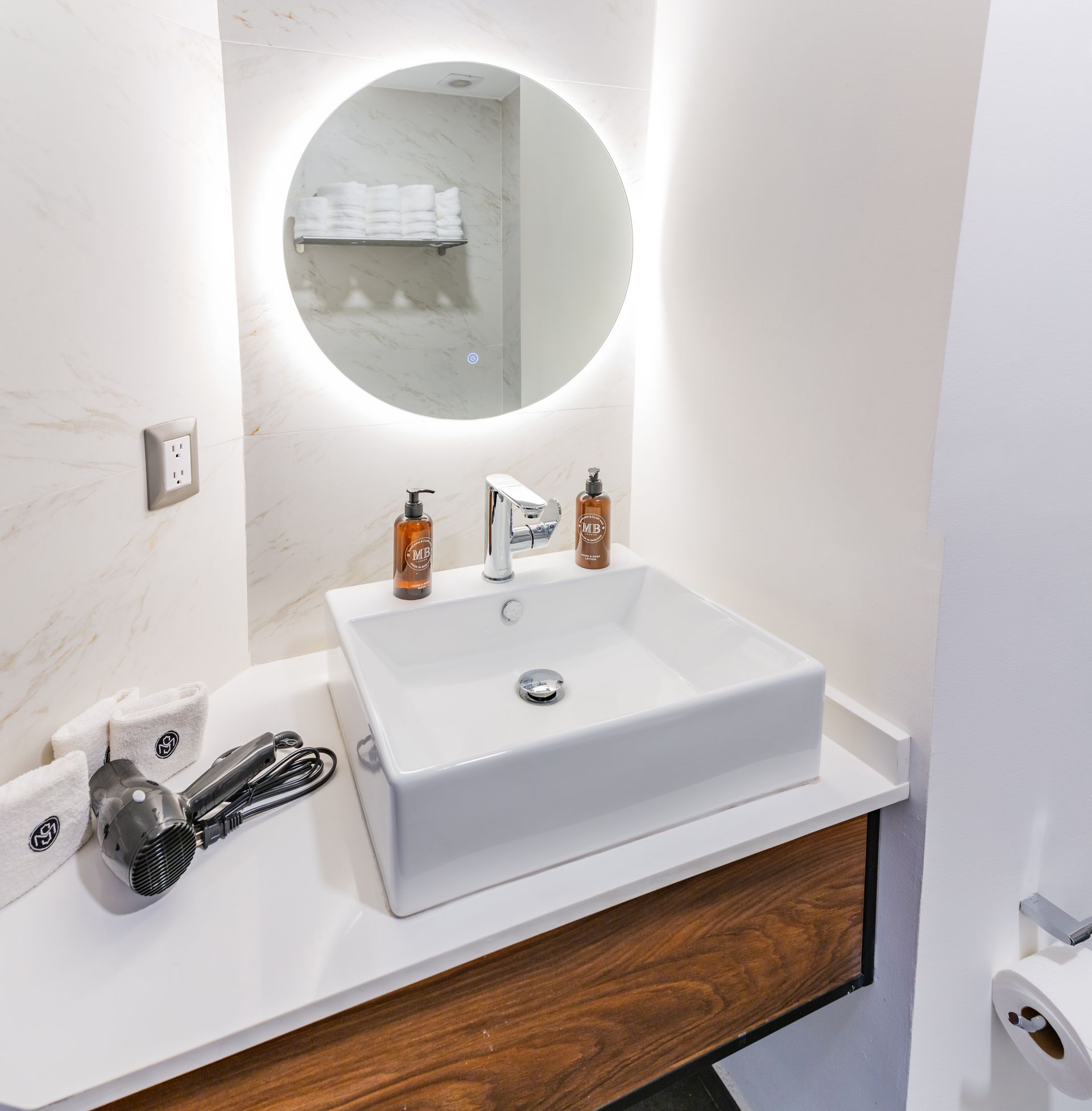Un baño con lavabo, espejo y secador de pelo.