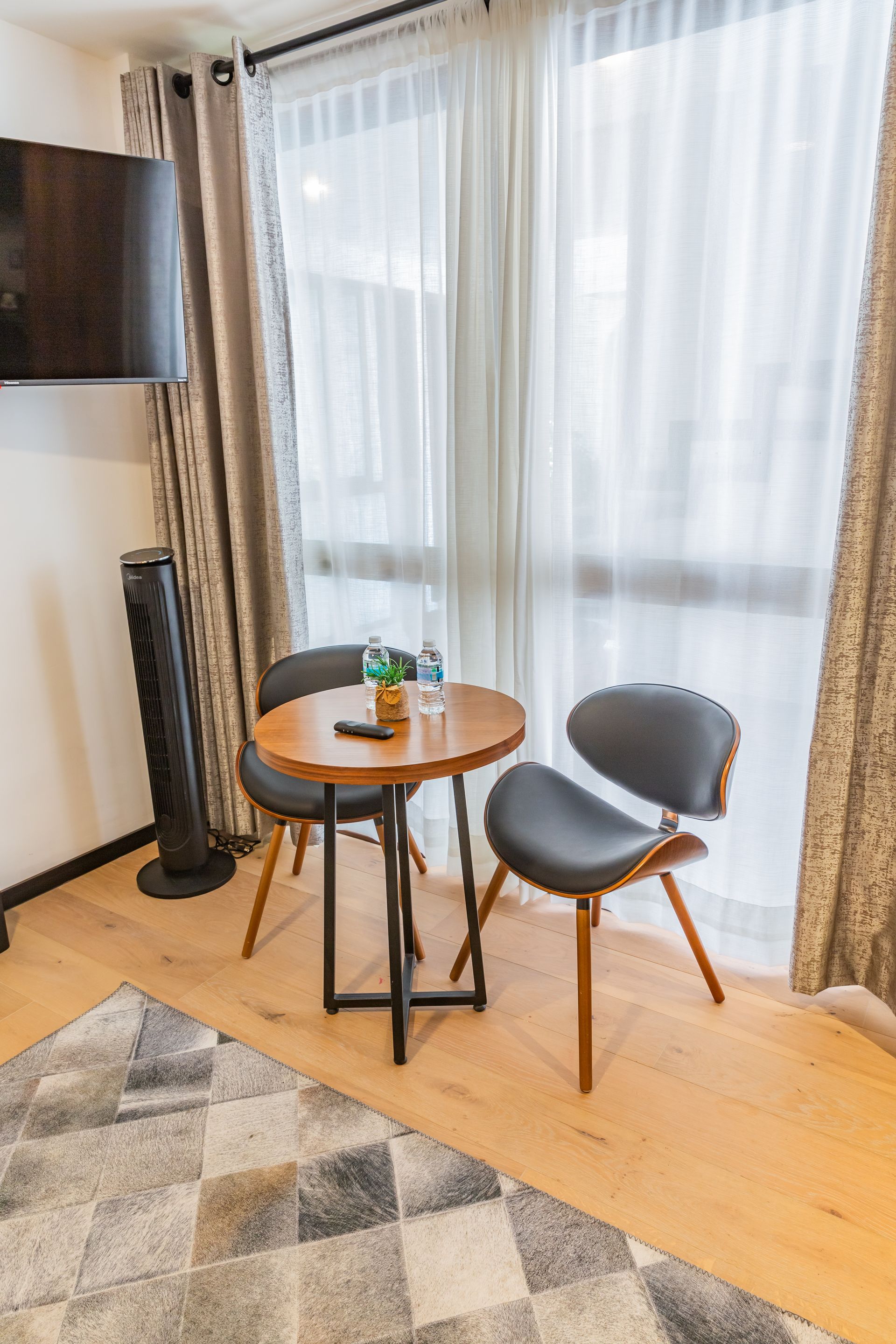Una sala de estar con una mesa y sillas frente a una ventana.
