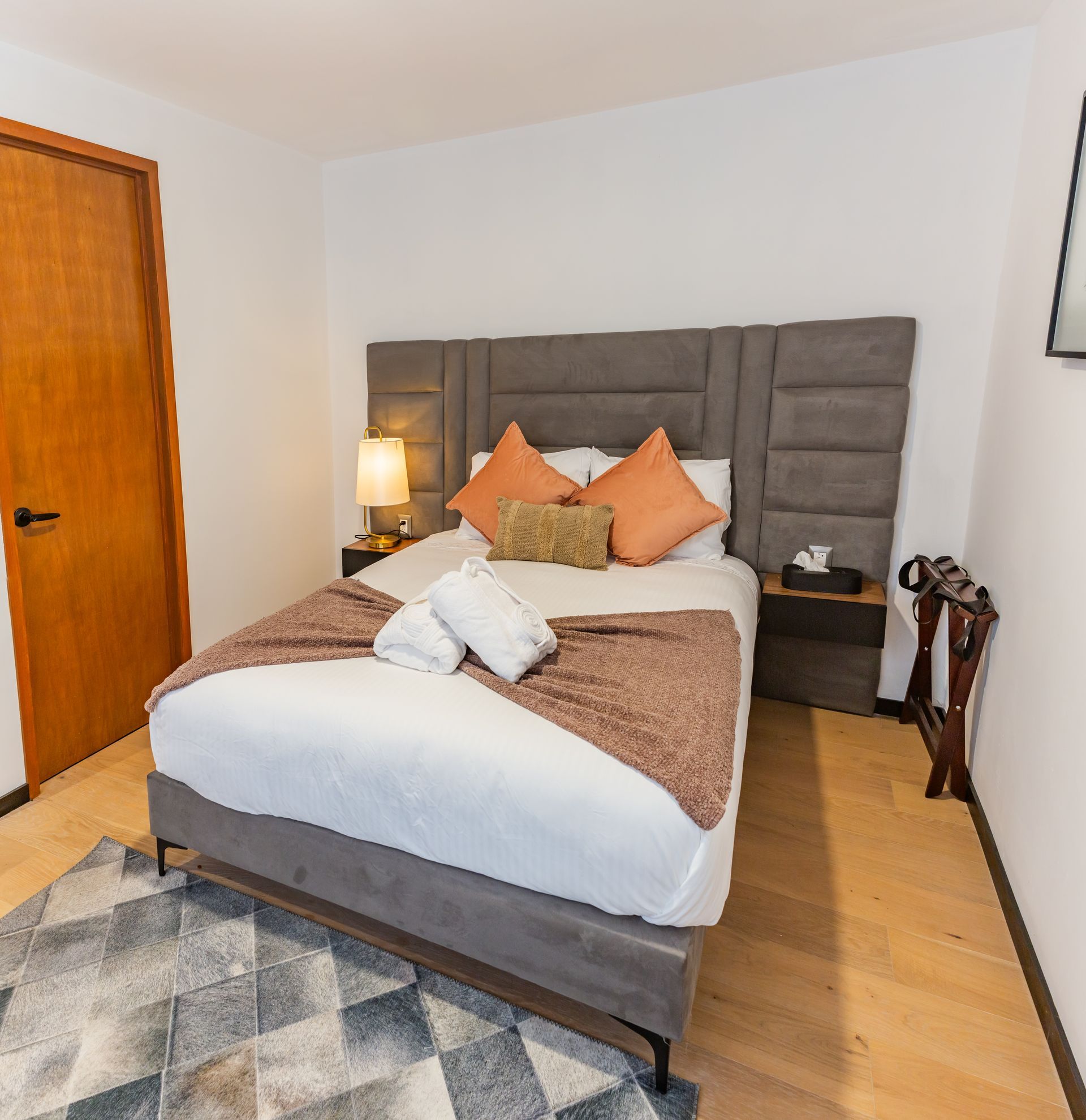 Una habitación de hotel con una cama grande y una alfombra.
