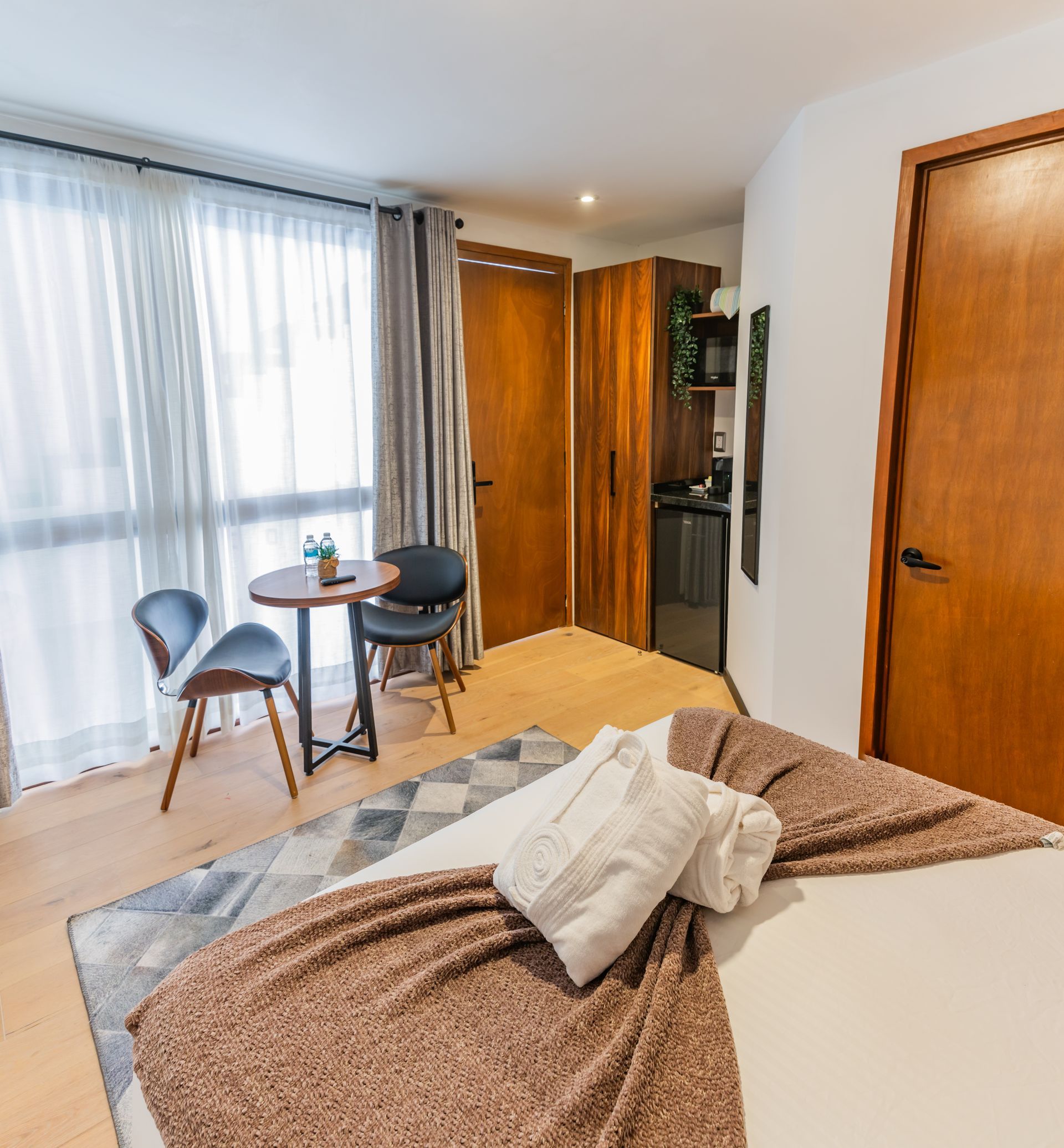 Un dormitorio con una cama, sillas y una mesa.