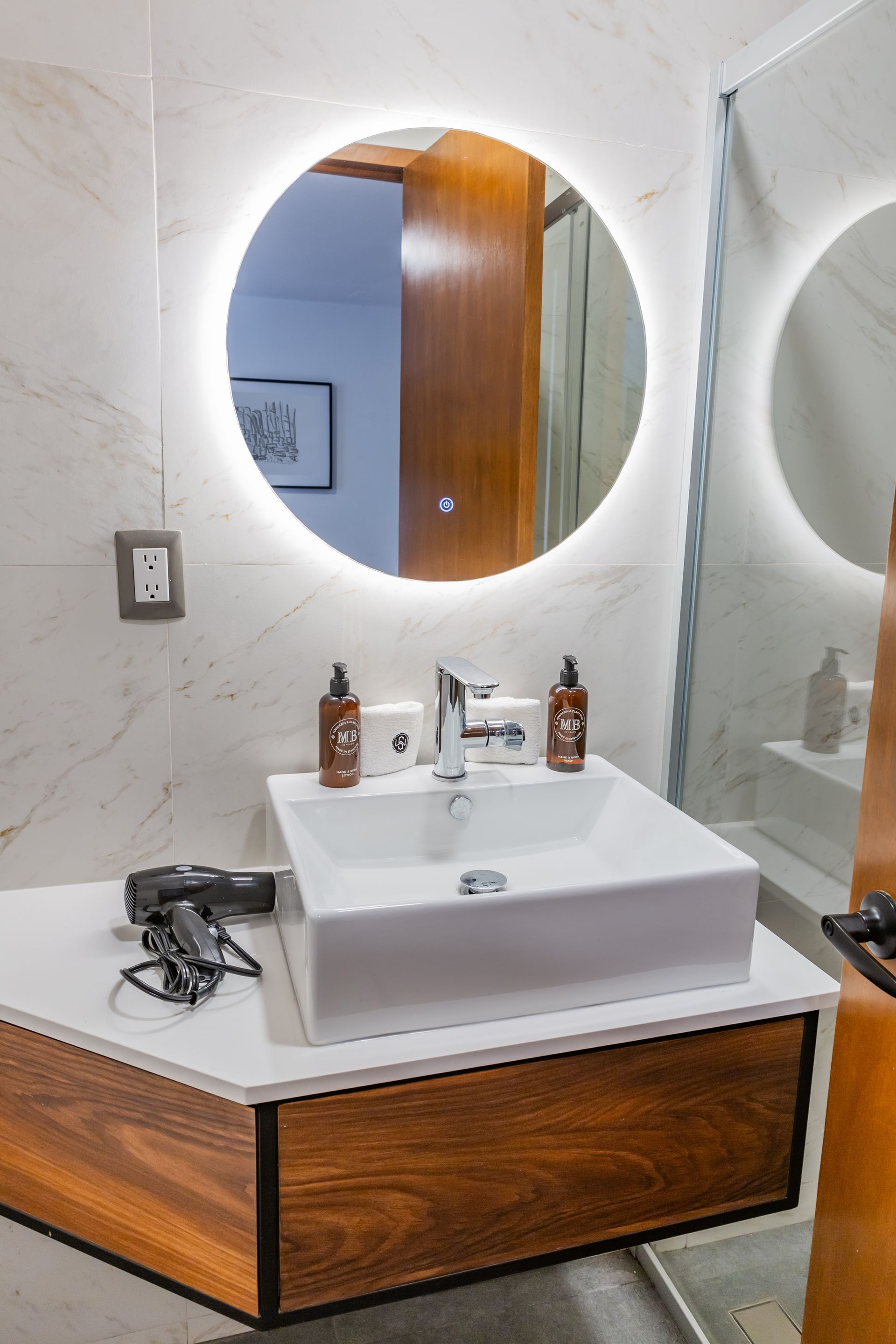 Un baño con lavabo, espejo y secador de pelo.