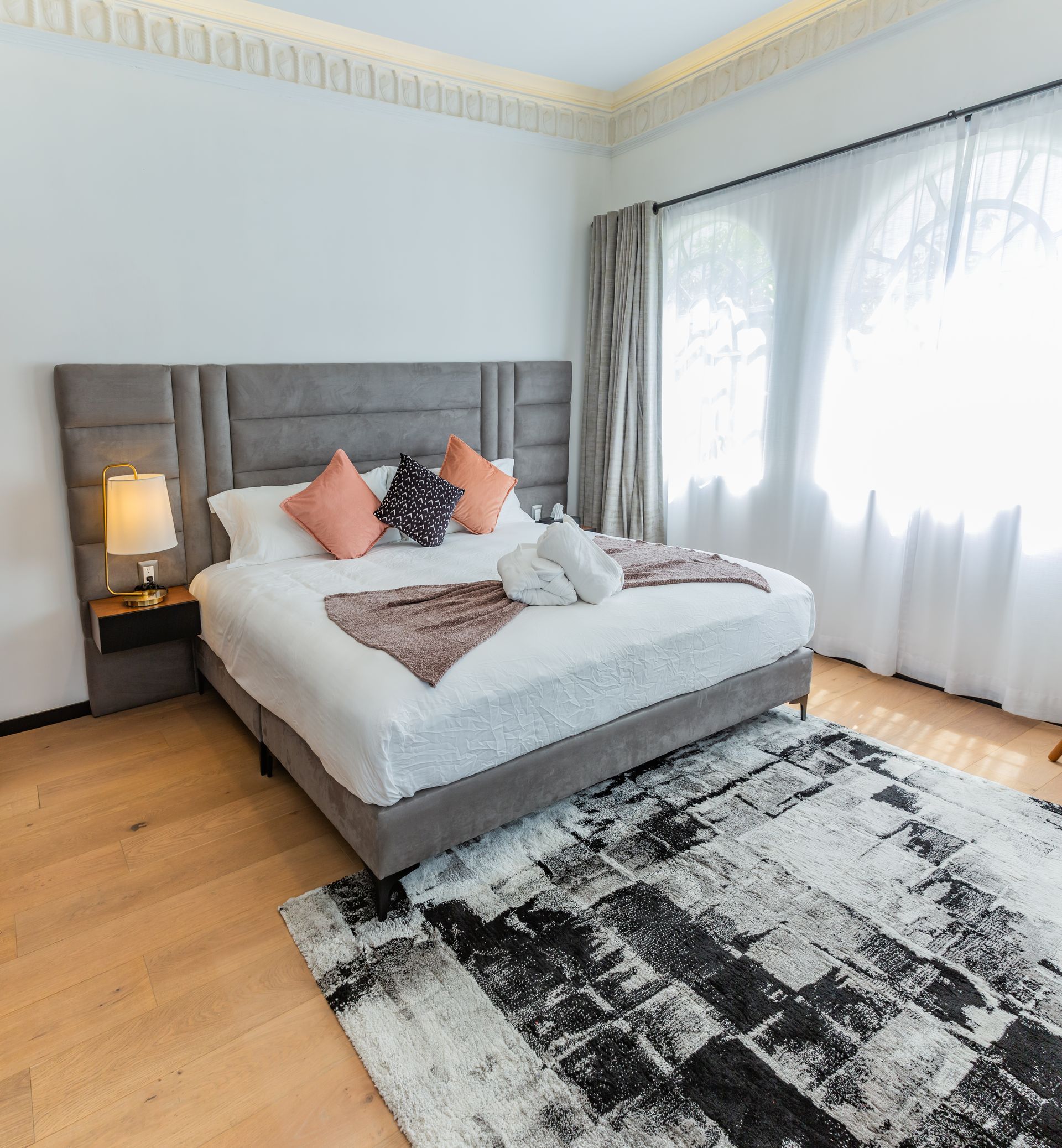 Un dormitorio con una cama king size y una alfombra.