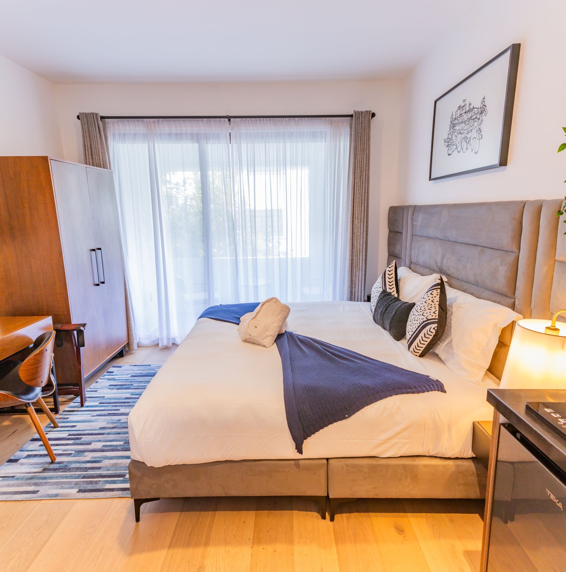 Un dormitorio con una cama grande y una puerta corrediza de vidrio.
