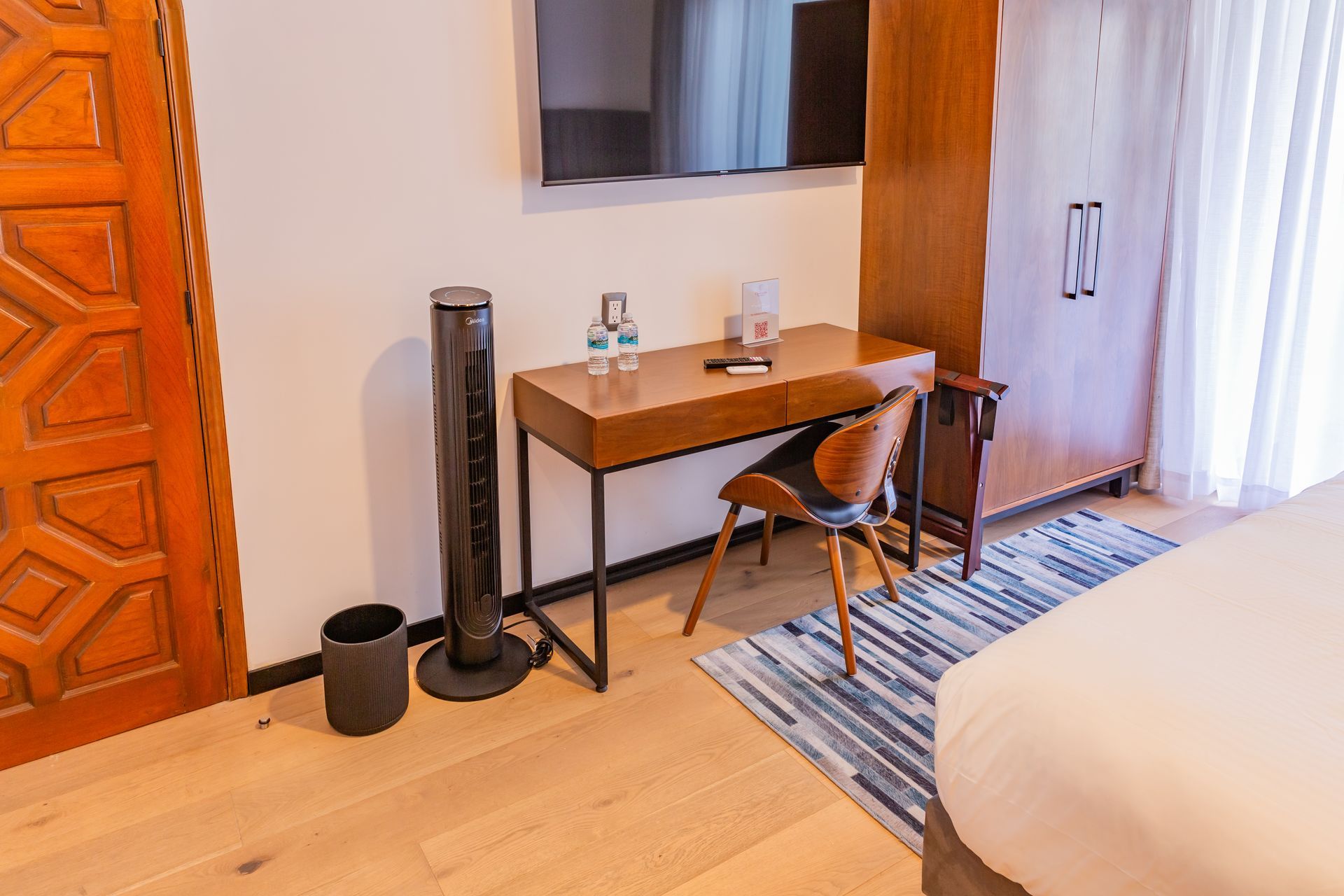 Una habitación de hotel con escritorio, silla y televisión.
