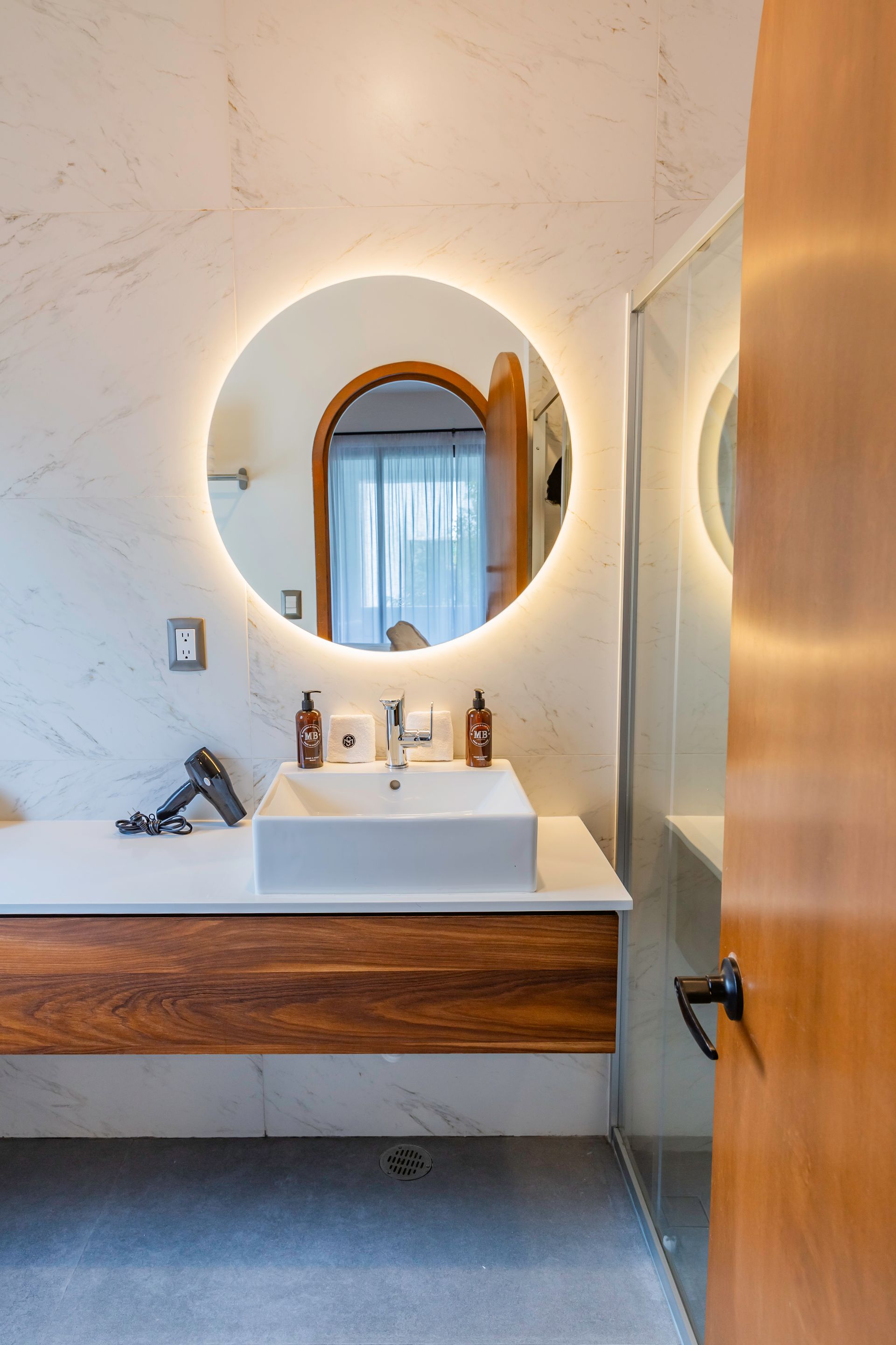 Un baño con lavabo, espejo y ducha.