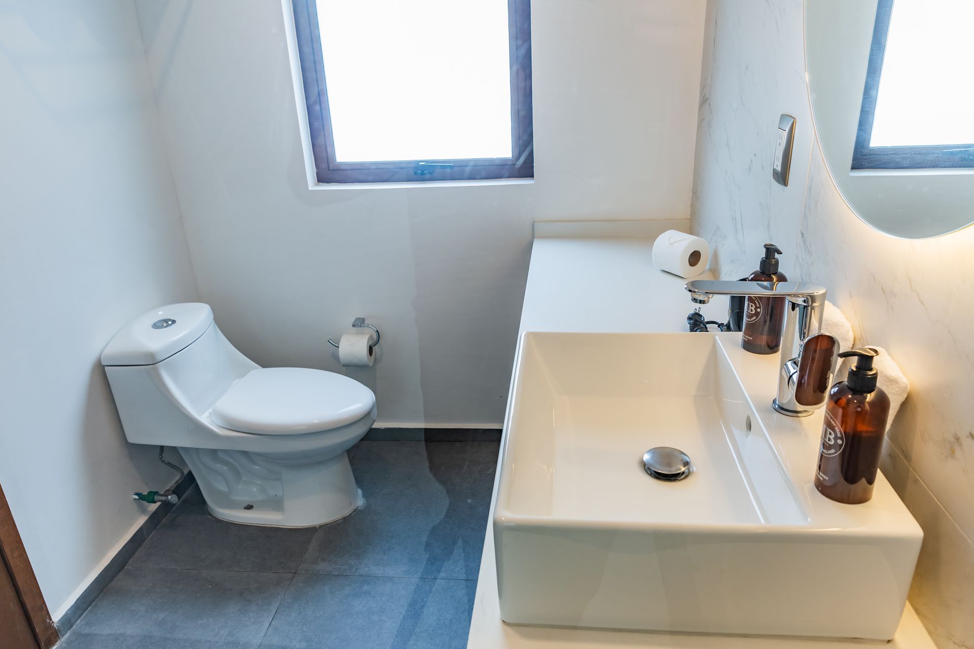 Un baño con inodoro, lavabo y espejo.
