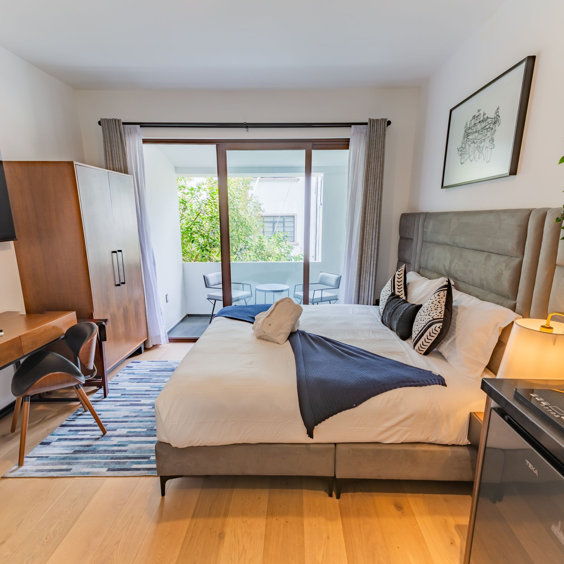 Un dormitorio con una cama grande y una puerta corrediza de vidrio.