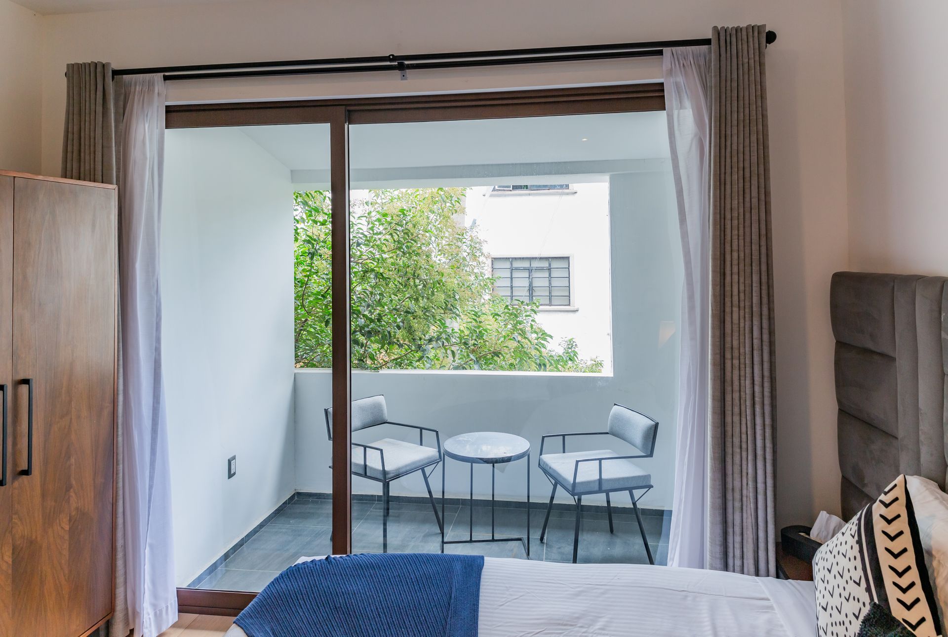 Un dormitorio con una puerta corrediza de vidrio que conduce a un balcón.