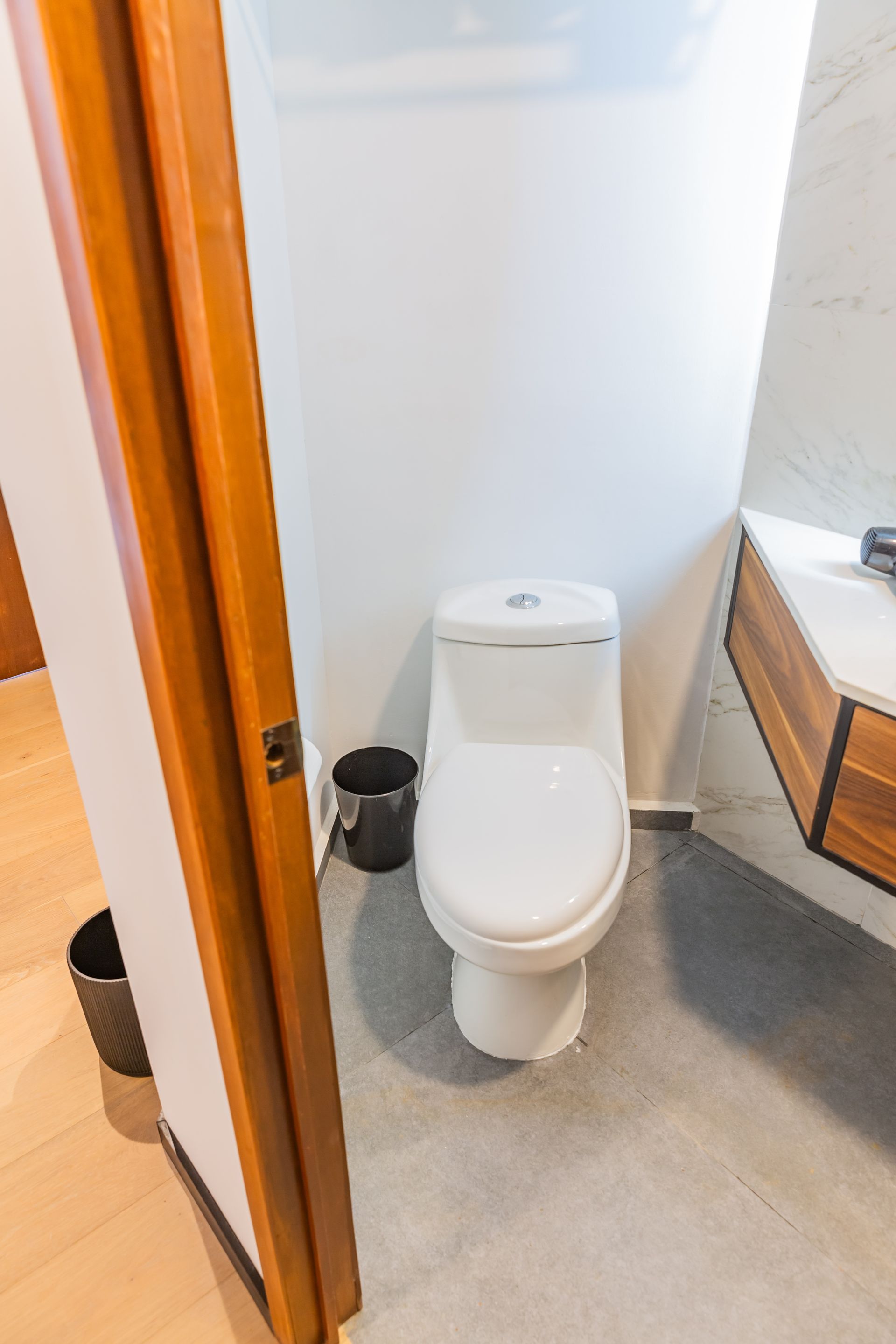 Un inodoro está sentado en un baño al lado de un lavabo.
