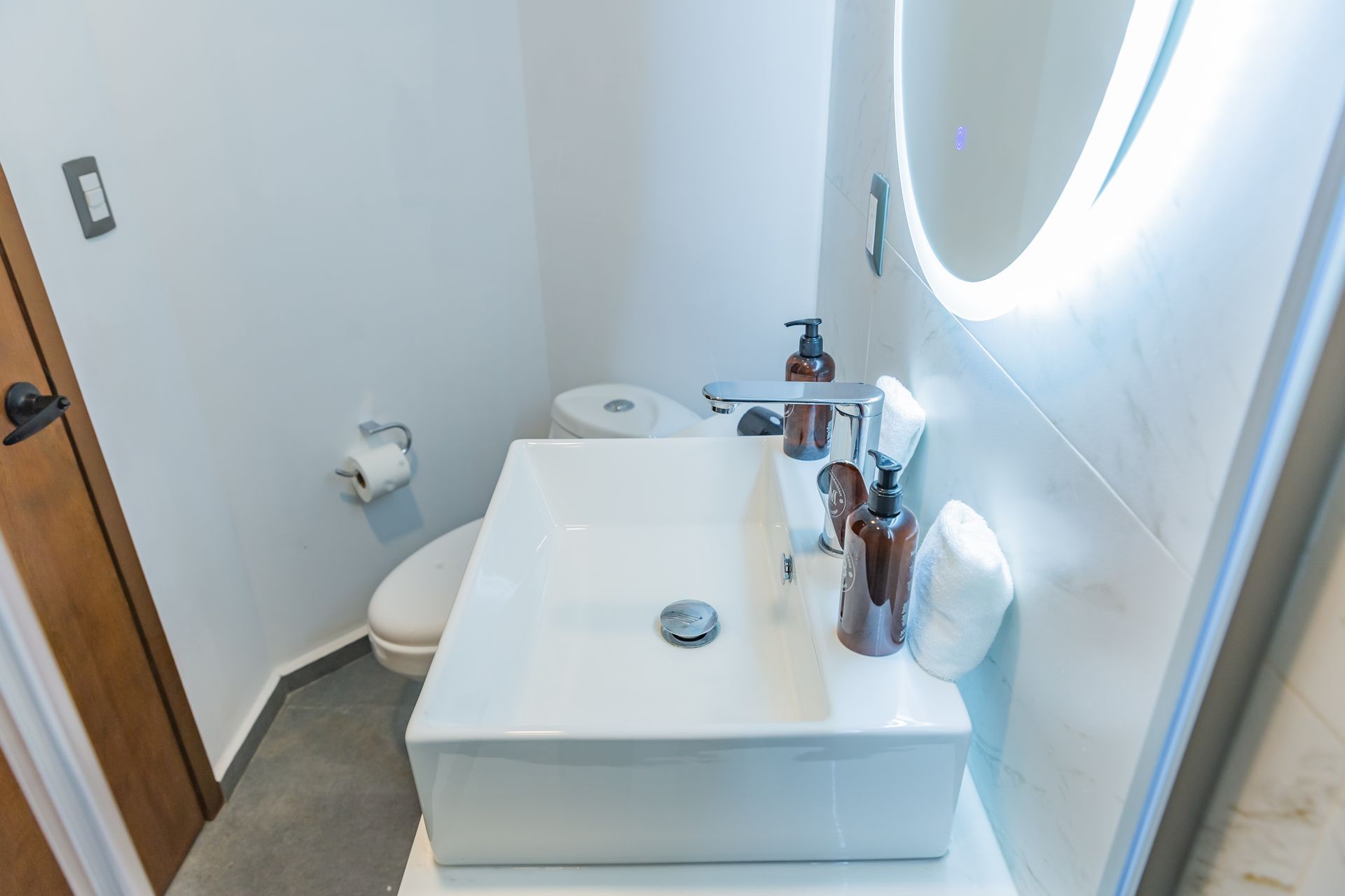 Un baño con lavabo, inodoro y espejo.