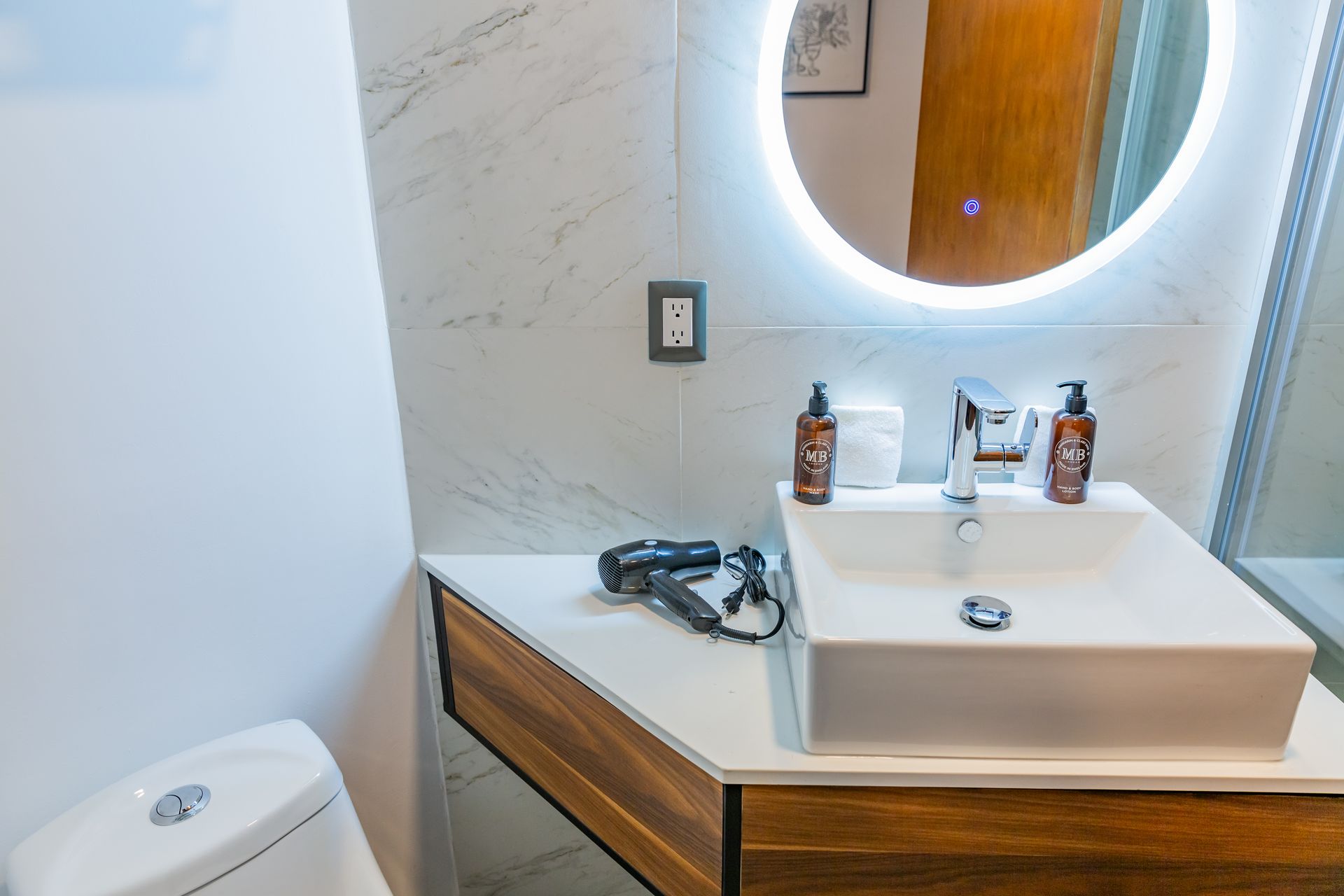 Un baño con lavabo, inodoro y espejo.