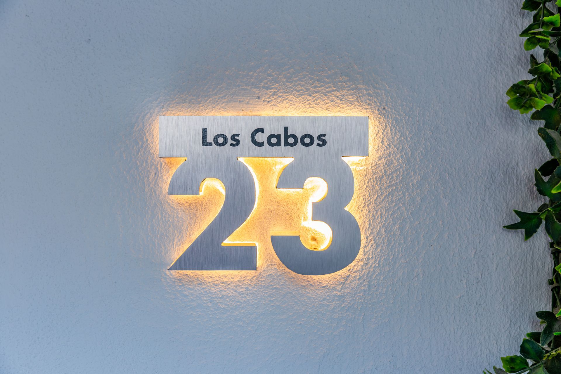 El número 23 está iluminado en una pared blanca.