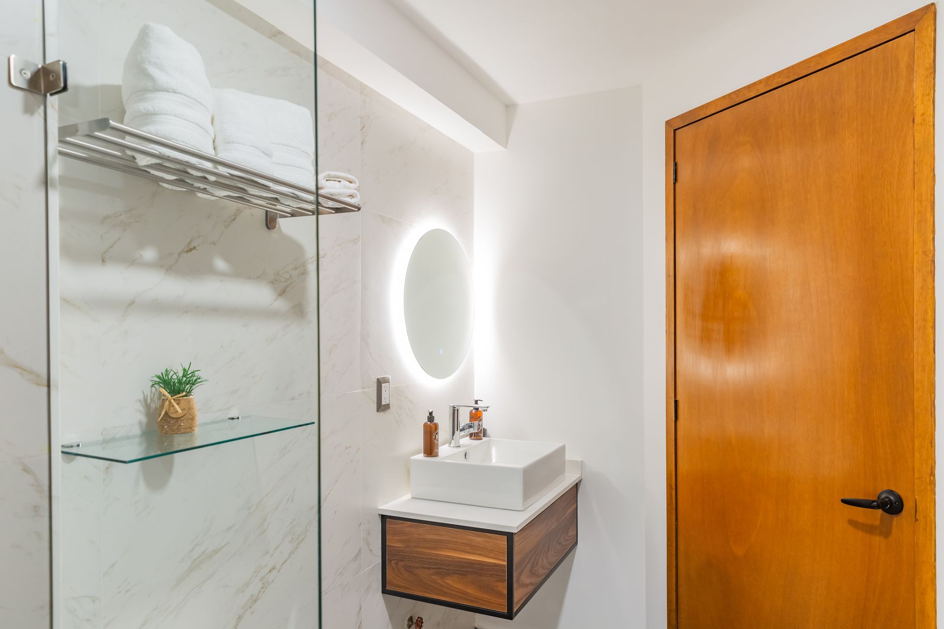 Un baño con lavabo, espejo y ducha.