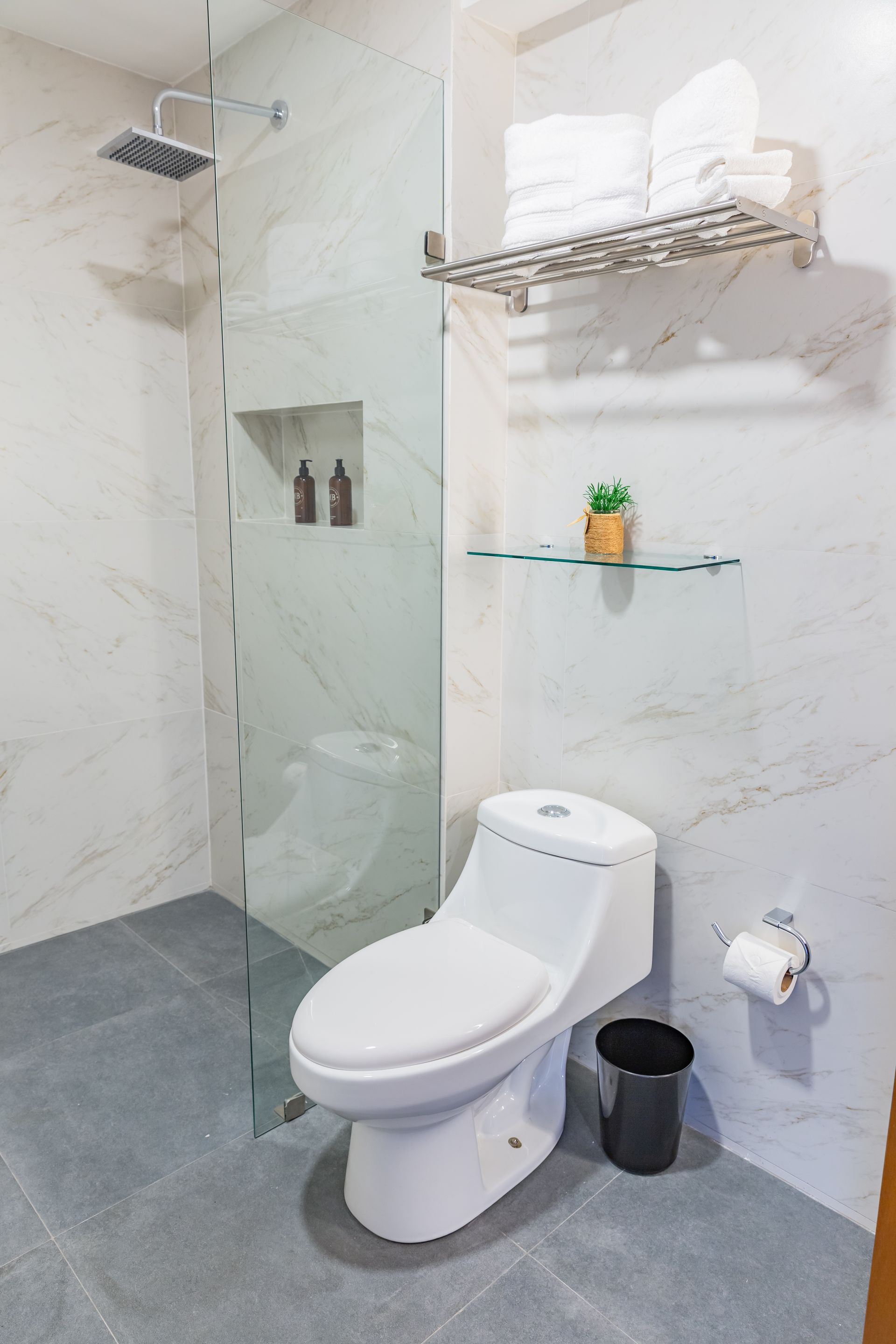 Un baño con inodoro y ducha a ras de suelo.
