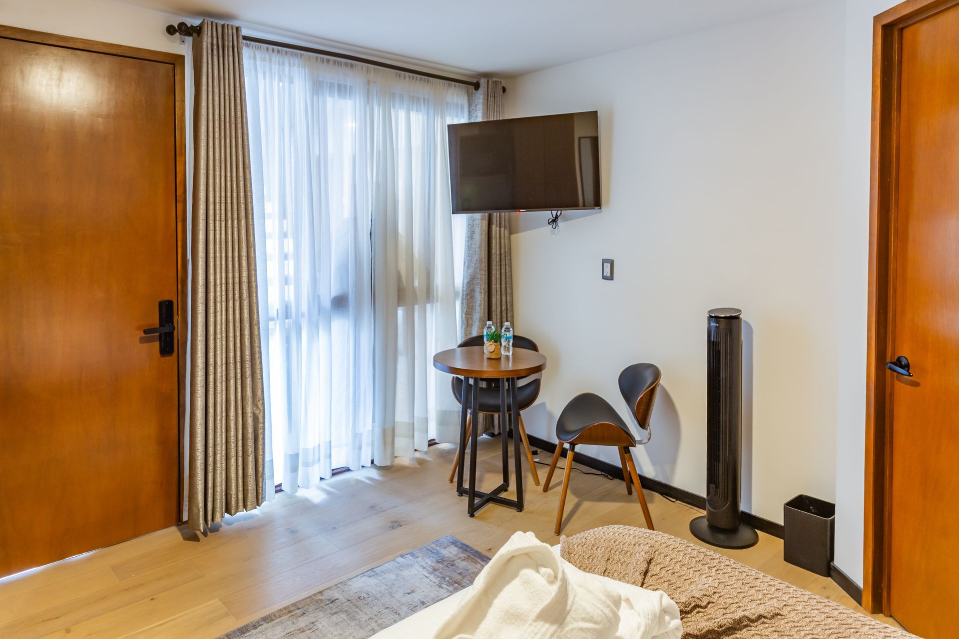 Una habitación de hotel con una cama, sillas, mesa y televisión.