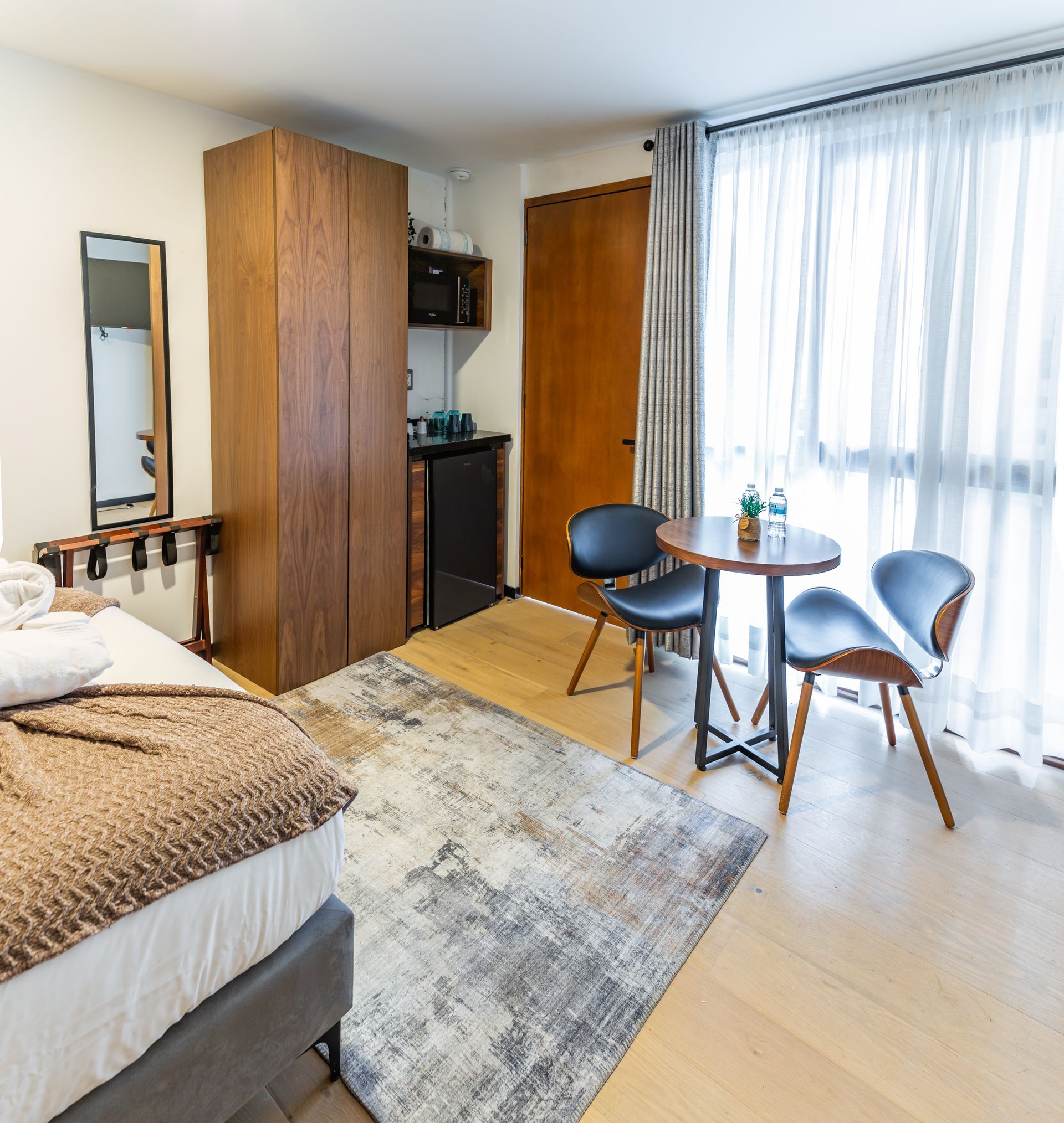 Una habitación de hotel con cama, mesa y sillas.