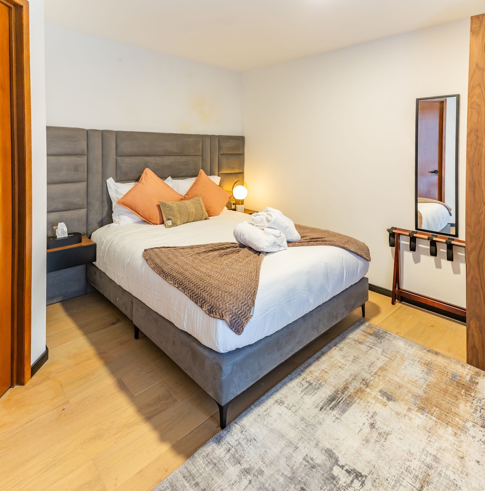 Una habitación de hotel con una cama grande y un espejo.
