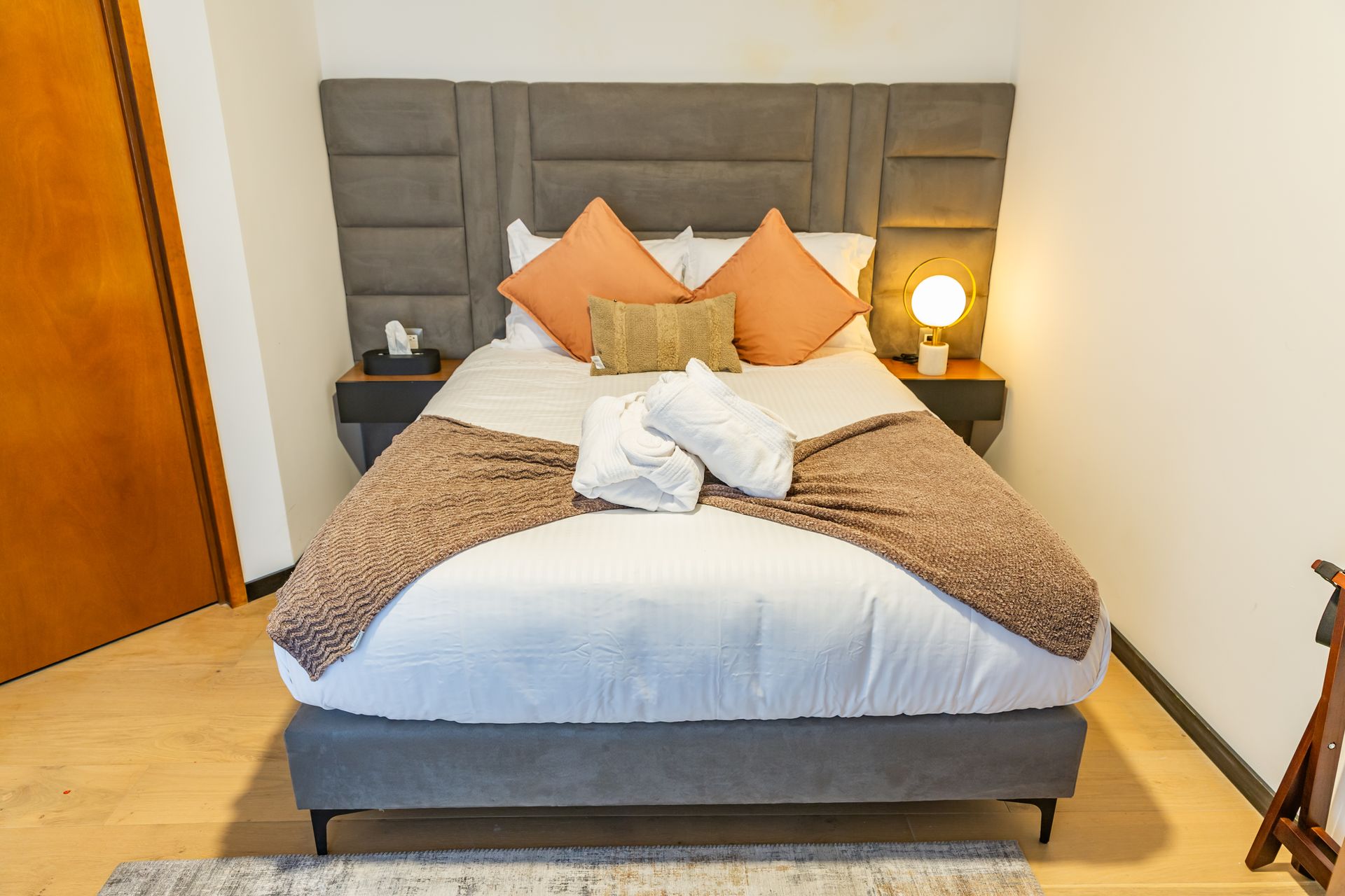 Una habitación de hotel con una cama tamaño king y dos mesitas de noche.