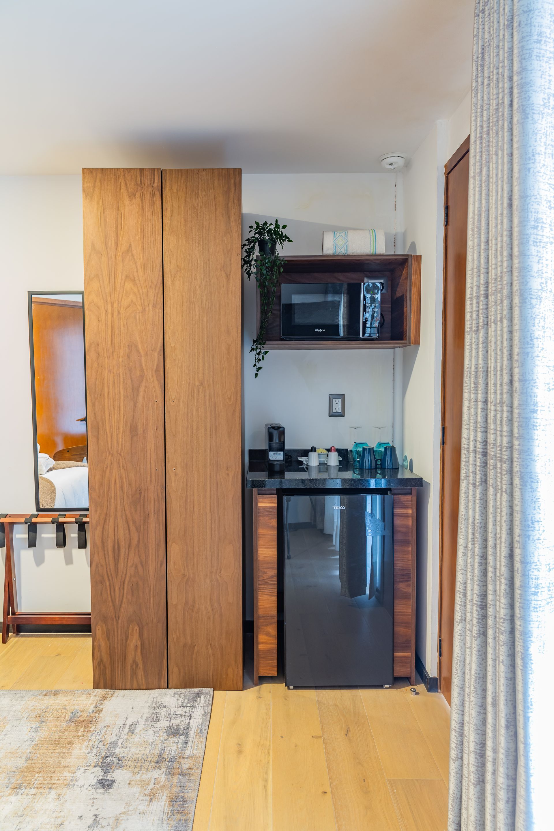 Una pequeña cocina con refrigerador, microondas y fregadero.