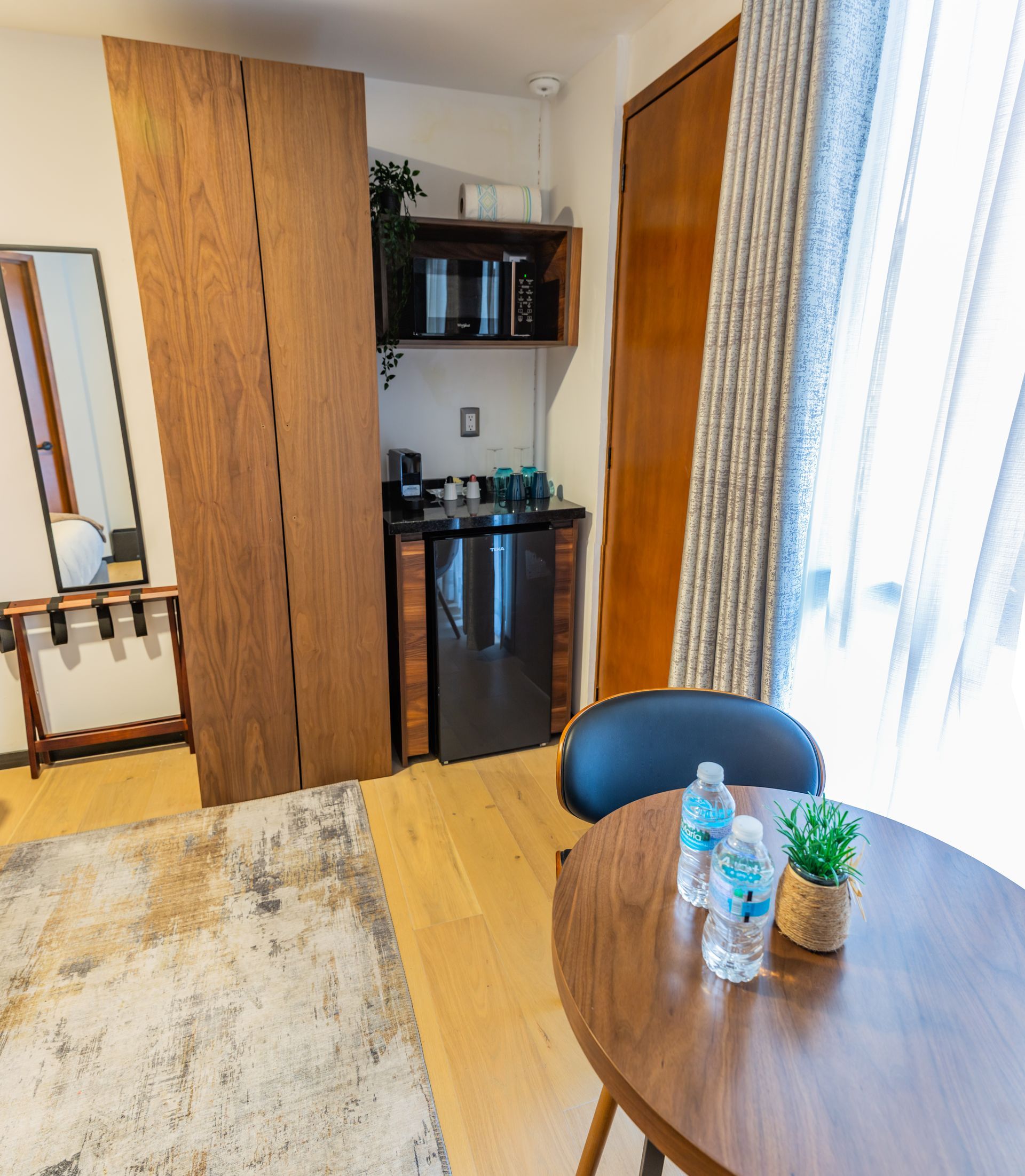 Una habitación con una mesa y sillas y botellas de agua encima.