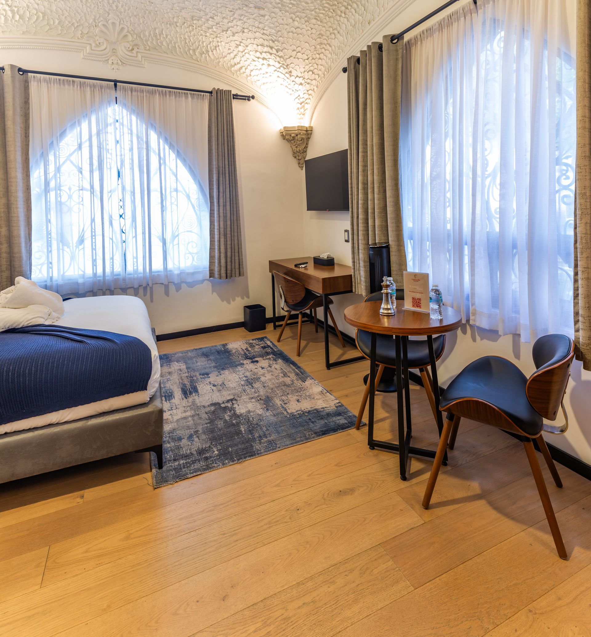 A hotel room with a bed , table and chairs