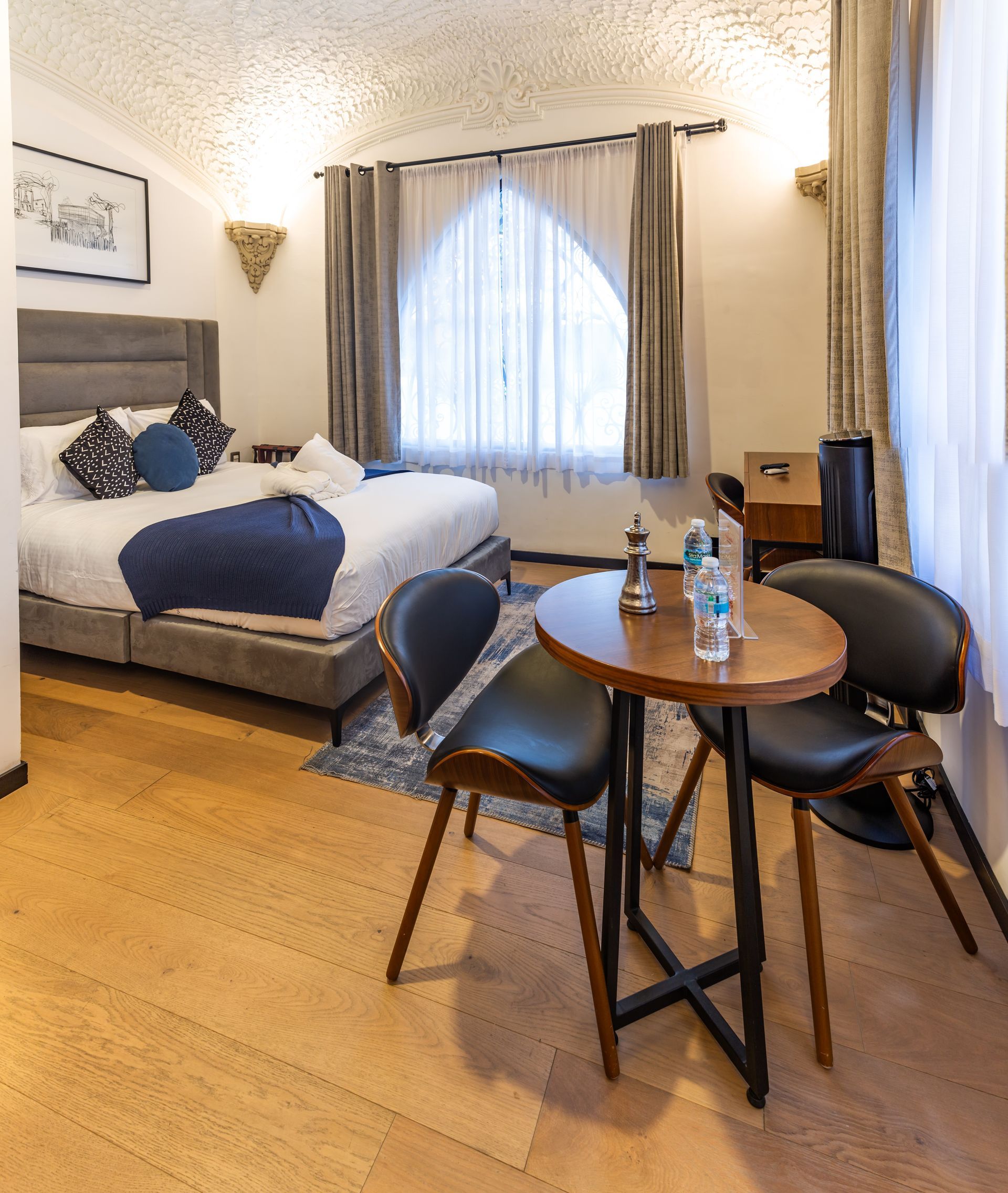 A hotel room with a bed , table and chairs