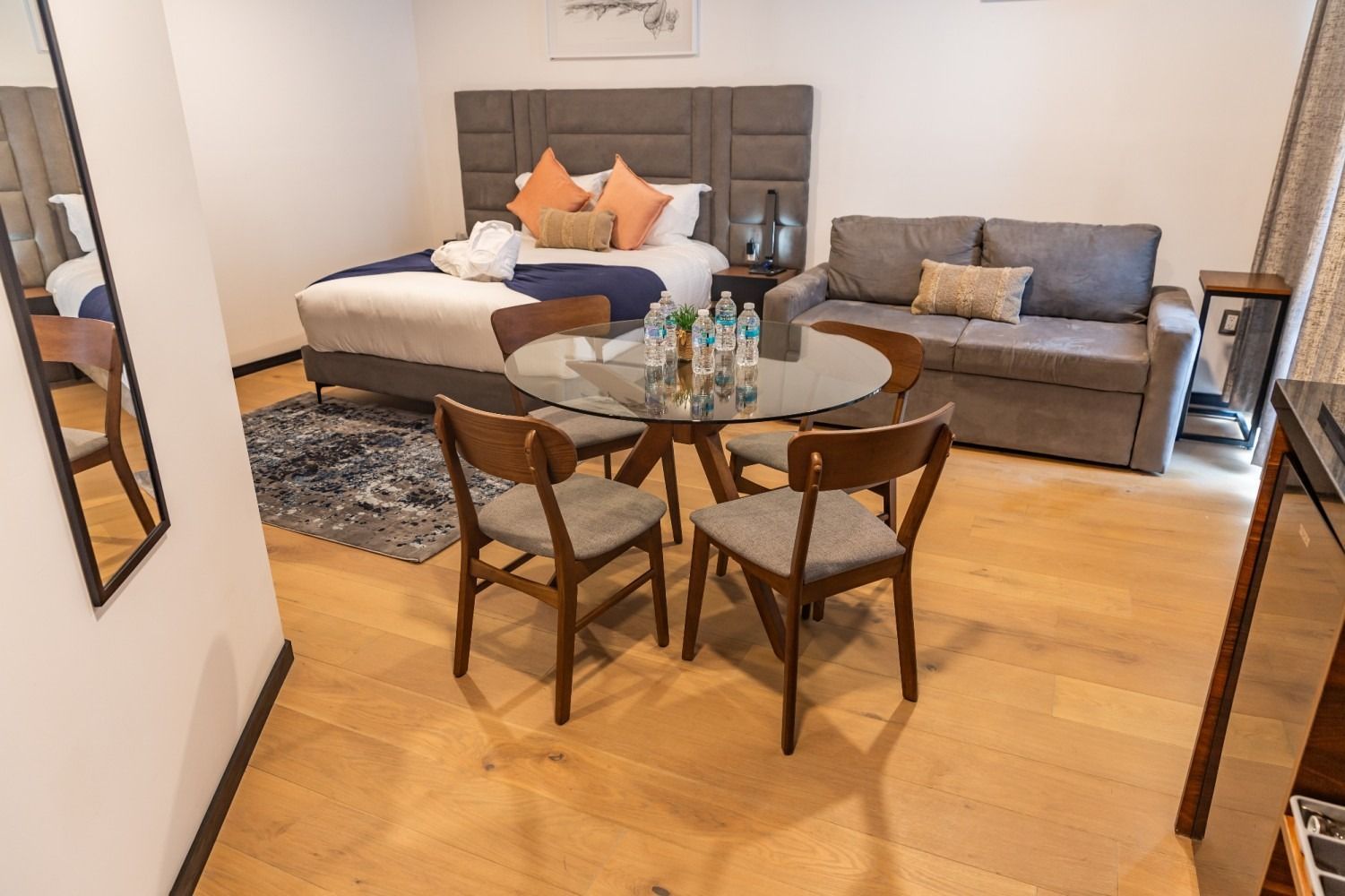 Una habitación de hotel con una cama, un sofá, una mesa y sillas.