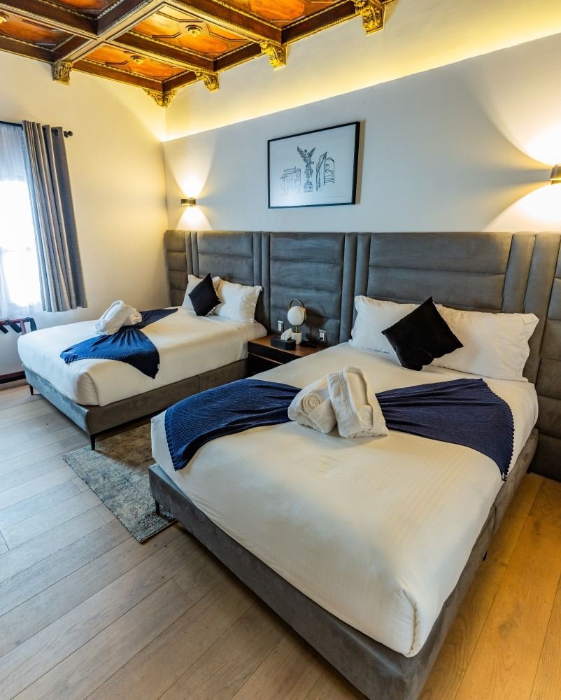 A hotel room with two beds and a chair.
