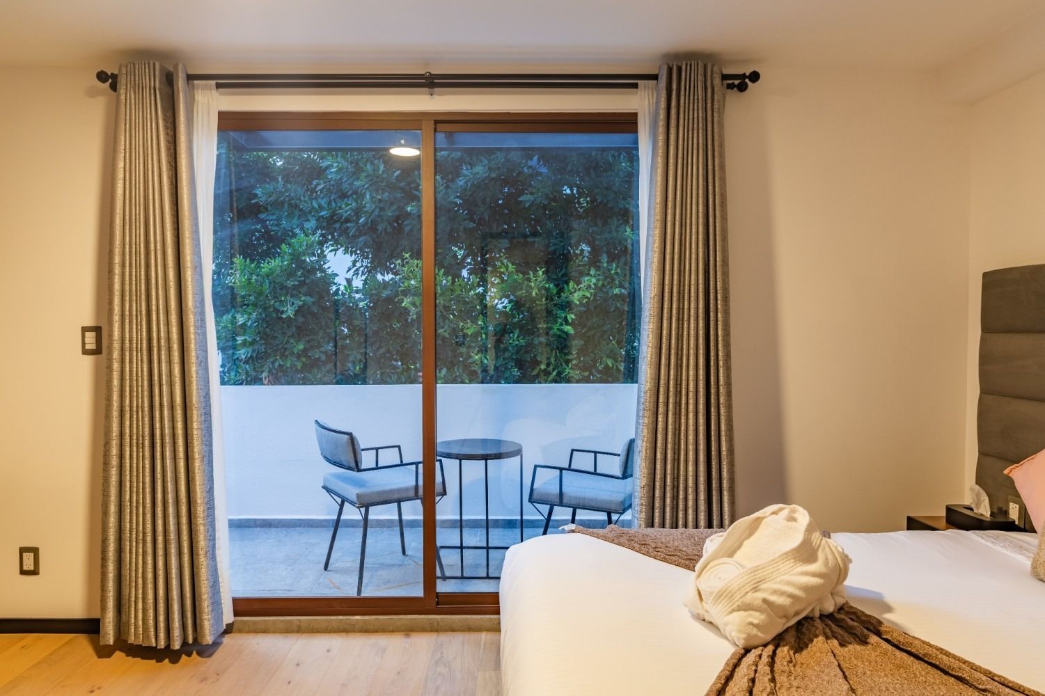 Una habitación de hotel con una puerta corrediza de vidrio que conduce a un balcón.