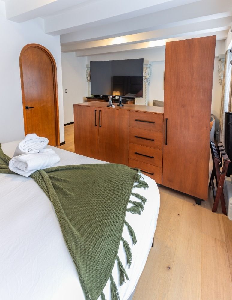 Un dormitorio con una cama king size y un televisor de pantalla plana.