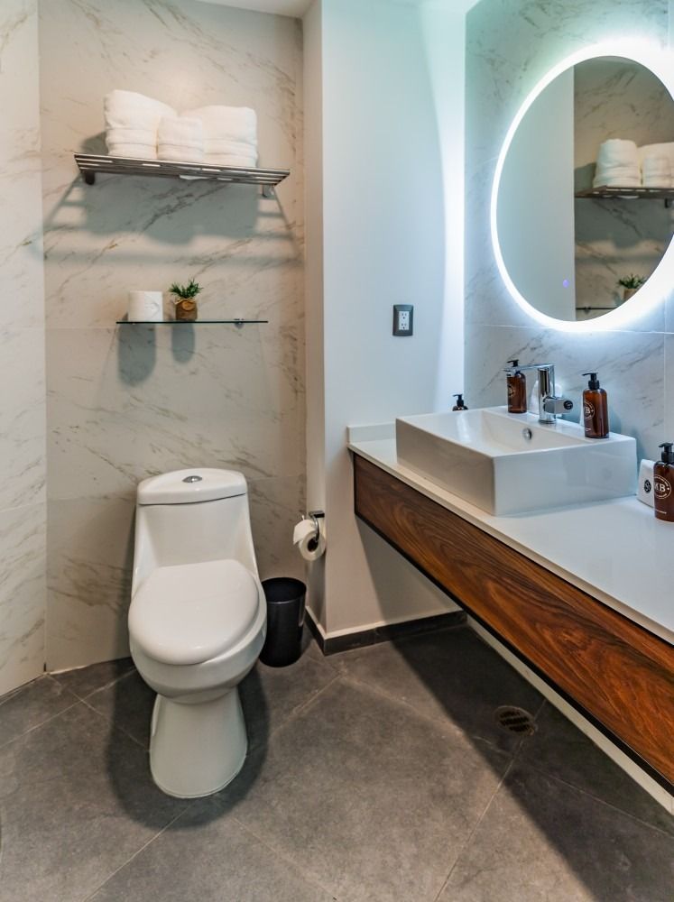 Un baño con inodoro, lavabo y espejo.