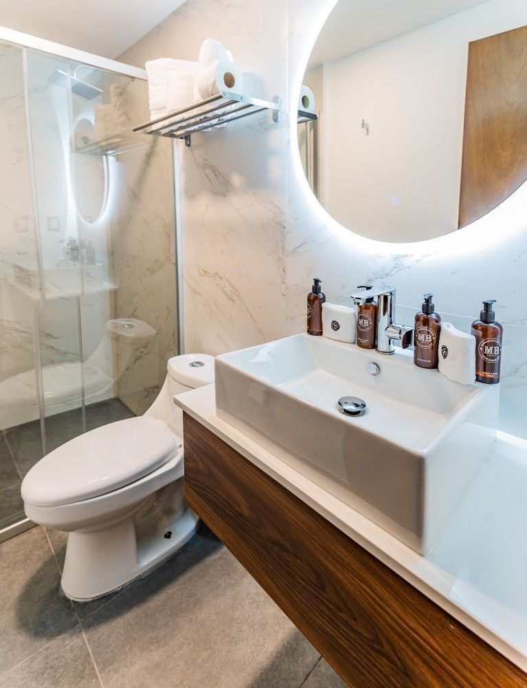 Un baño con inodoro, lavabo y espejo.