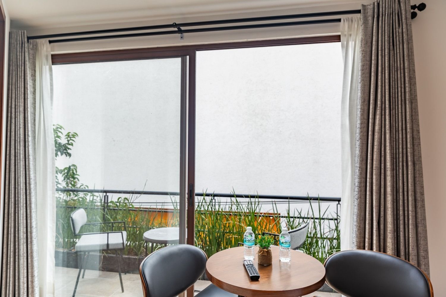 Una habitación con una mesa y sillas frente a una puerta corrediza de vidrio.