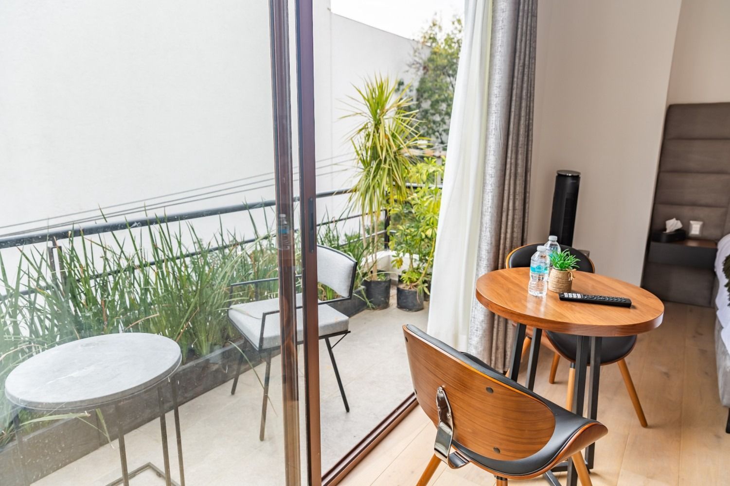 Una habitación de hotel con una mesa y sillas y un balcón.