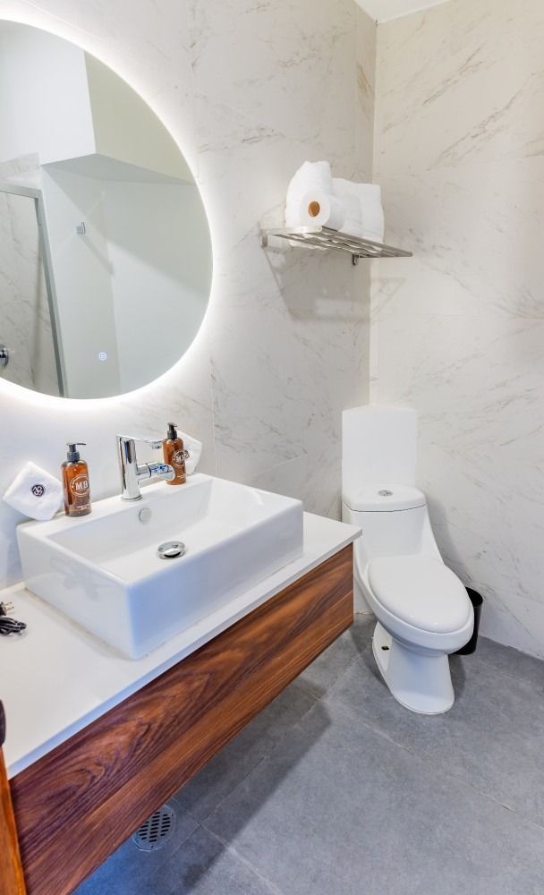 Un baño con lavabo, inodoro y espejo.